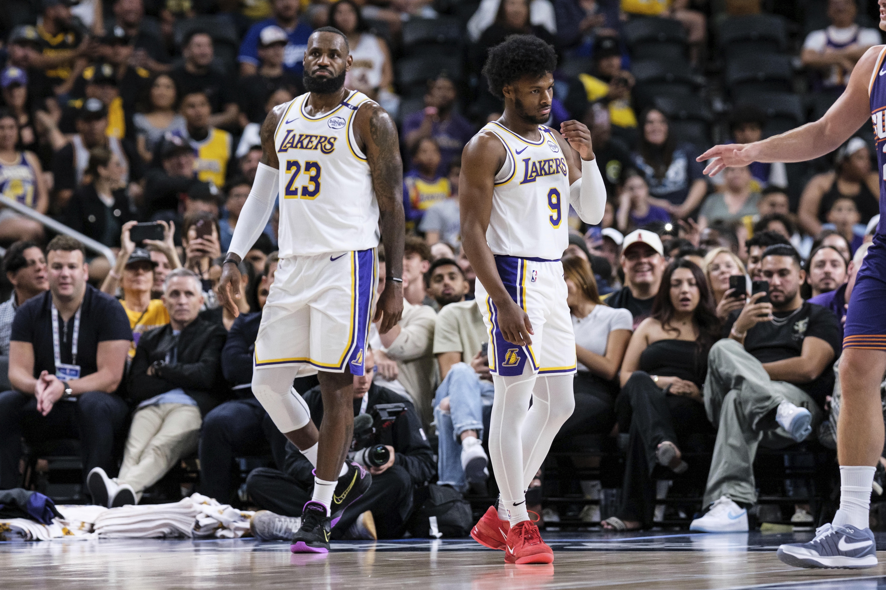 Los Angeles Lakers guard Bronny James (9), right, walks onto the court with forward LeBron James (23) during the first half of a preseason NBA basketball game against the Phoenix Suns, Sunday, Oct. 6, 2024, in Palm Desert, Calif. (AP Photo/William Liang)    Associated Press / LaPresse Only italy and spain