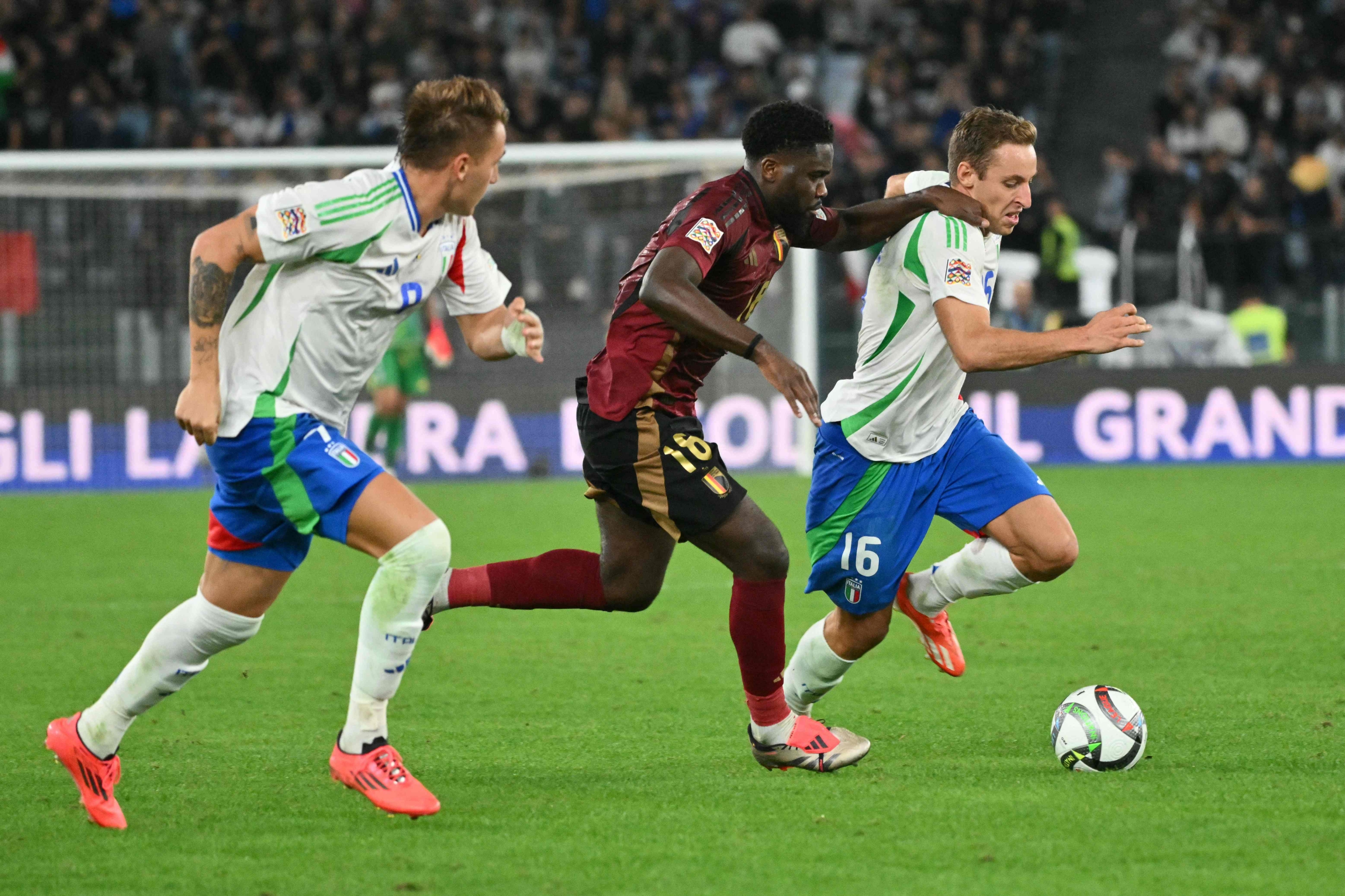 Italy's midfielder #16 Davide Frattesi (R) and Belgium's midfielder #18 Orel Mangala (C) fight for the ball during the UEFA Nations League, League A, Group A2 football match between Italy and Belgium at the Stadio Olimpico in Rome on October 10, 2024. (Photo by Alberto PIZZOLI / AFP)