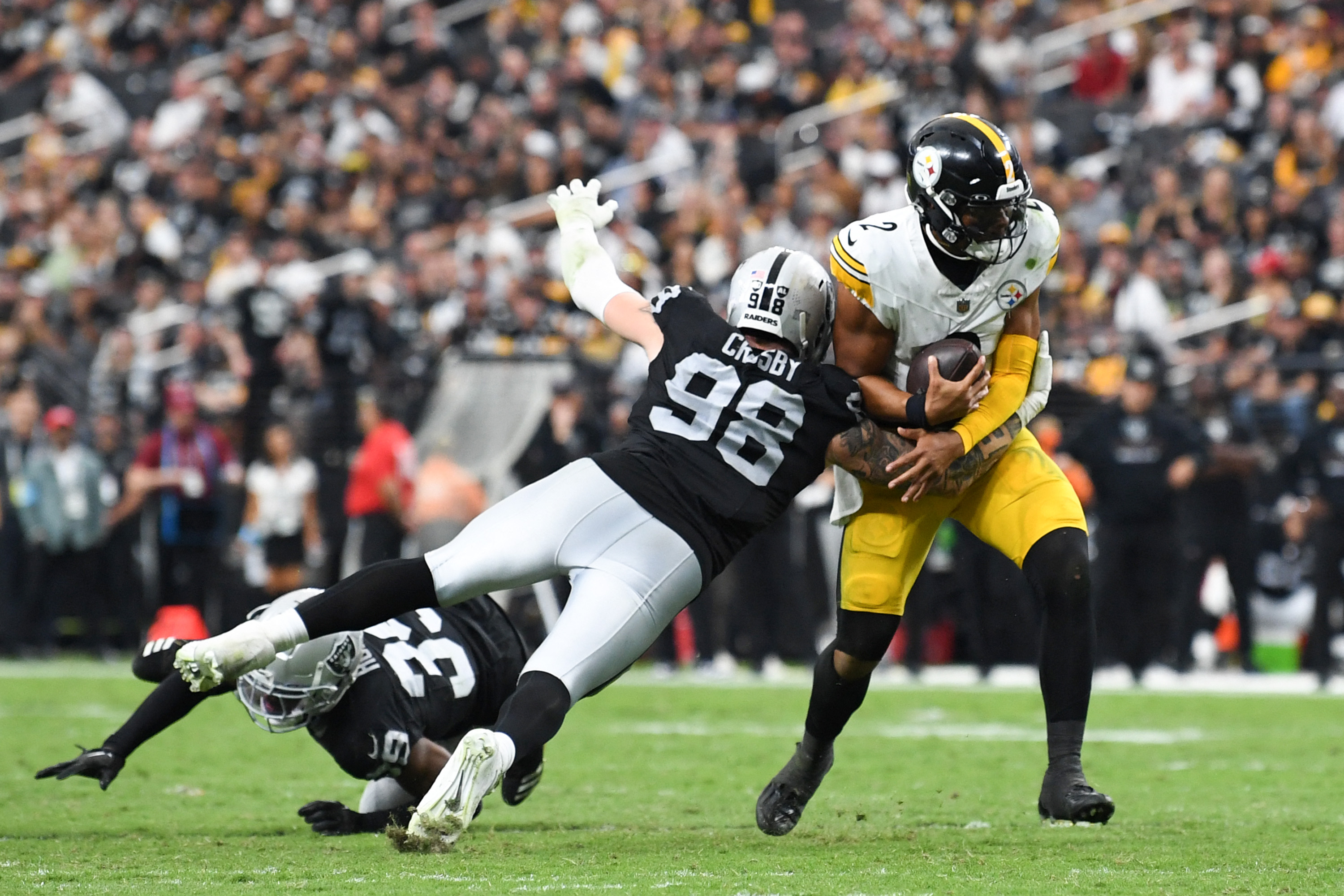 LAS VEGAS, NEVADA - OCTOBER 13: Maxx Crosby #98 of the Las Vegas Raiders sacks Justin Fields #2 of the Pittsburgh Steelers in the fourth quarter of a game at Allegiant Stadium on October 13, 2024 in Las Vegas, Nevada.   Candice Ward/Getty Images/AFP (Photo by Candice Ward / GETTY IMAGES NORTH AMERICA / Getty Images via AFP)