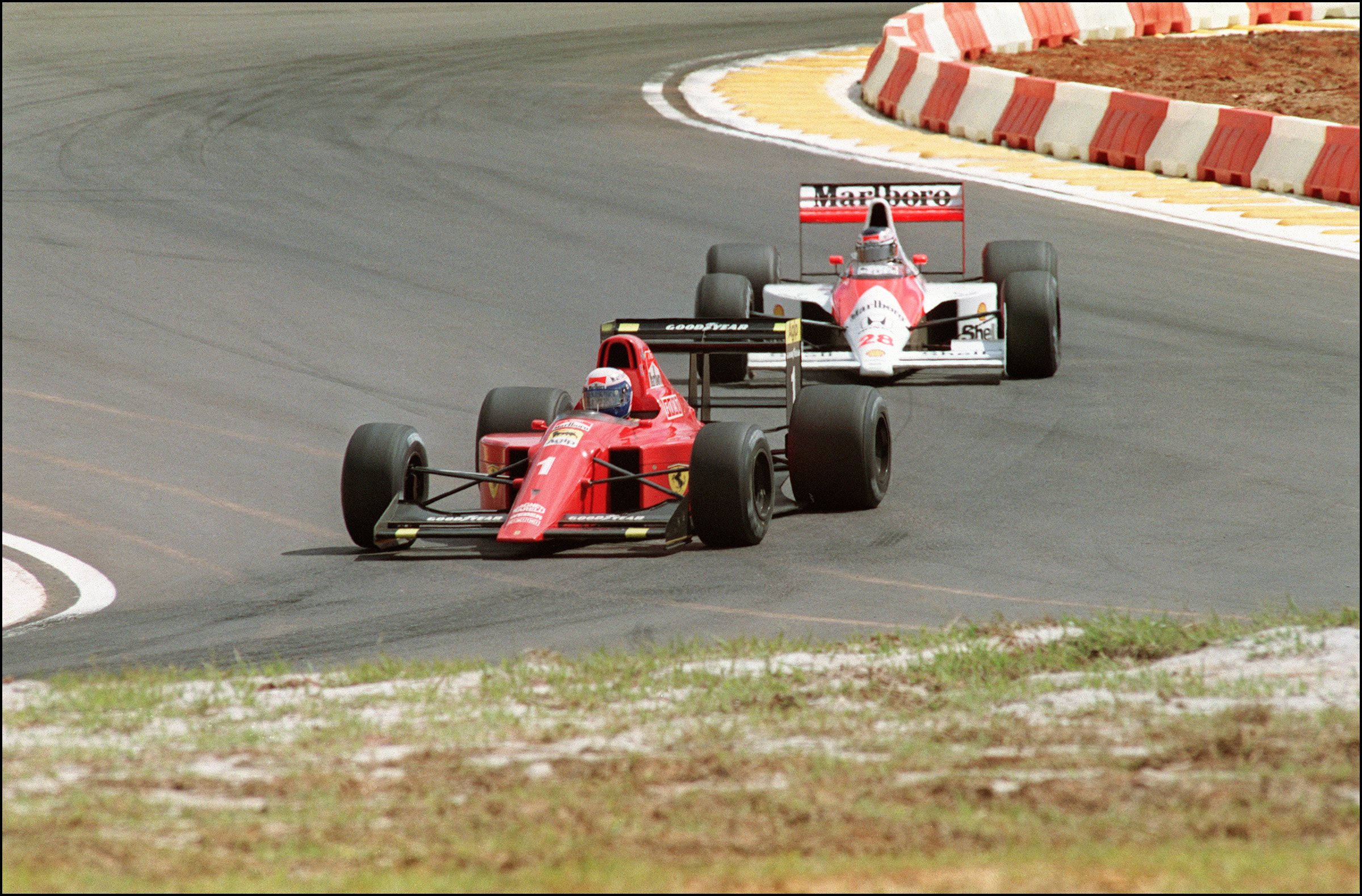 Austrian Formula One driver Gerhard Berger (28) tails French driver Alain Prost (1) during Brazilian Grand Prix 25 March 1990. Berger finished second behind Prost who claimed his first victory of the 1990 season. (Photo by ANTONIO SCORZA / AFP)