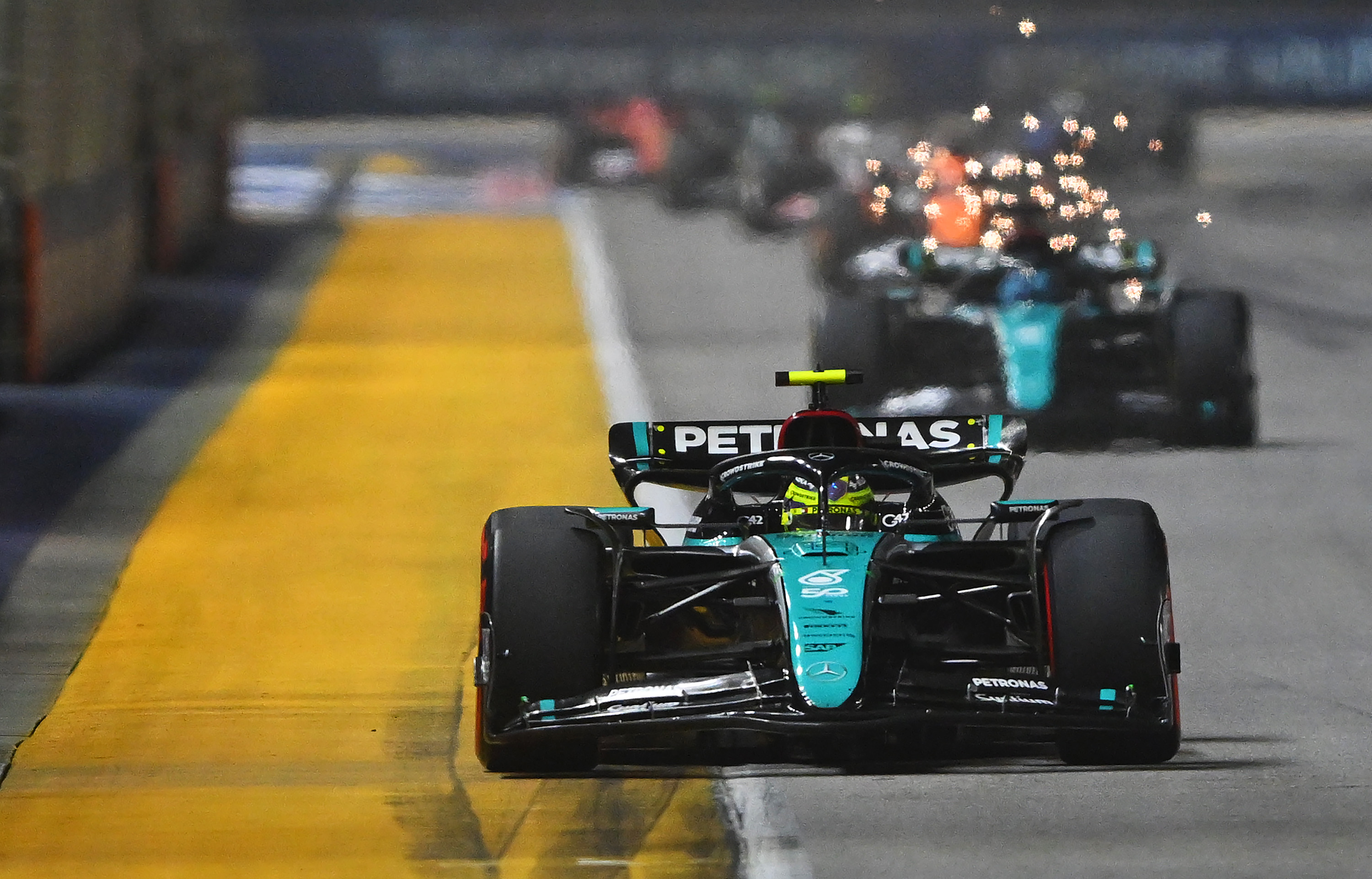 SINGAPORE, SINGAPORE - SEPTEMBER 22: Lewis Hamilton of Great Britain driving the (44) Mercedes AMG Petronas F1 Team W15 leads George Russell of Great Britain driving the (63) Mercedes AMG Petronas F1 Team W15 on track during the F1 Grand Prix of Singapore at Marina Bay Street Circuit on September 22, 2024 in Singapore, Singapore. (Photo by Rudy Carezzevoli/Getty Images)