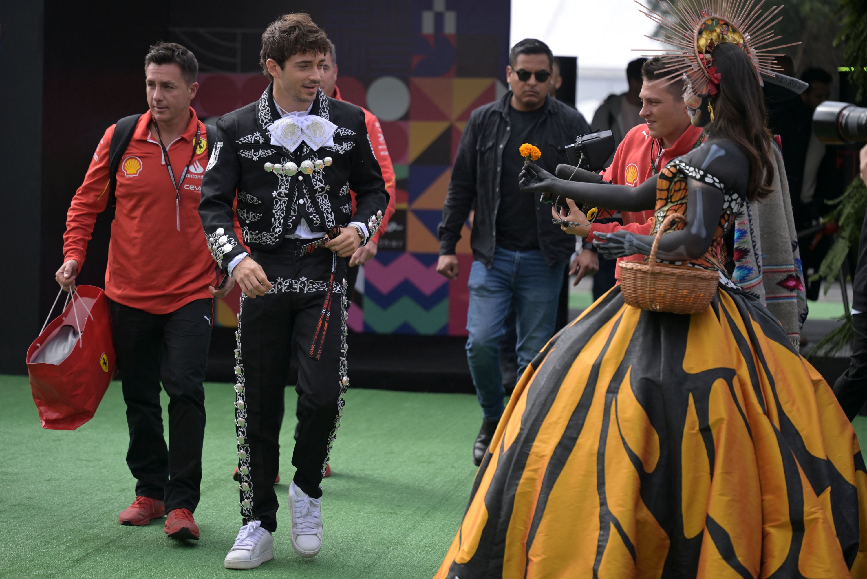 Ferrari's Monegasque driver Charles Leclerc dressed in traditional Mexican mariachi costume walks on arrival at the Hermanos Rodriguez racetrack, in Mexico City on October 24, 2024, ahead of the upcoming Mexico City Grand Prix next October 27. (Photo by Yuri CORTEZ / AFP)