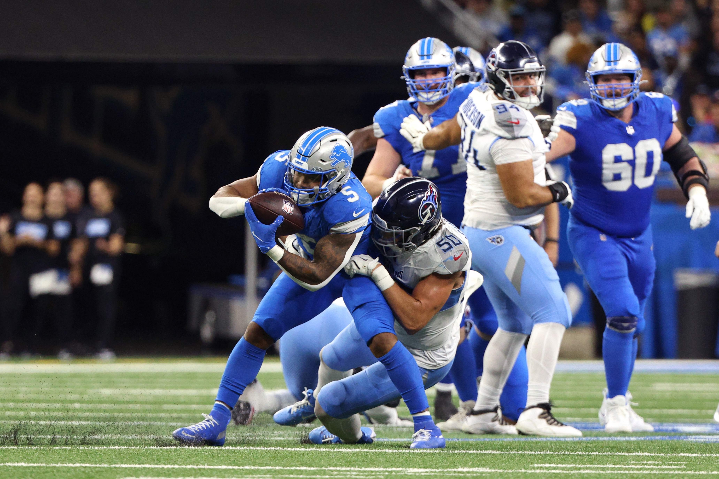 DETROIT, MICHIGAN - OCTOBER 27: Jack Gibbens #50 of the Tennessee Titans tackles David Montgomery #5 of the Detroit Lions in the third quarter of a gameat Ford Field on October 27, 2024 in Detroit, Michigan.   Mike Mulholland/Getty Images/AFP (Photo by Mike Mulholland / GETTY IMAGES NORTH AMERICA / Getty Images via AFP)