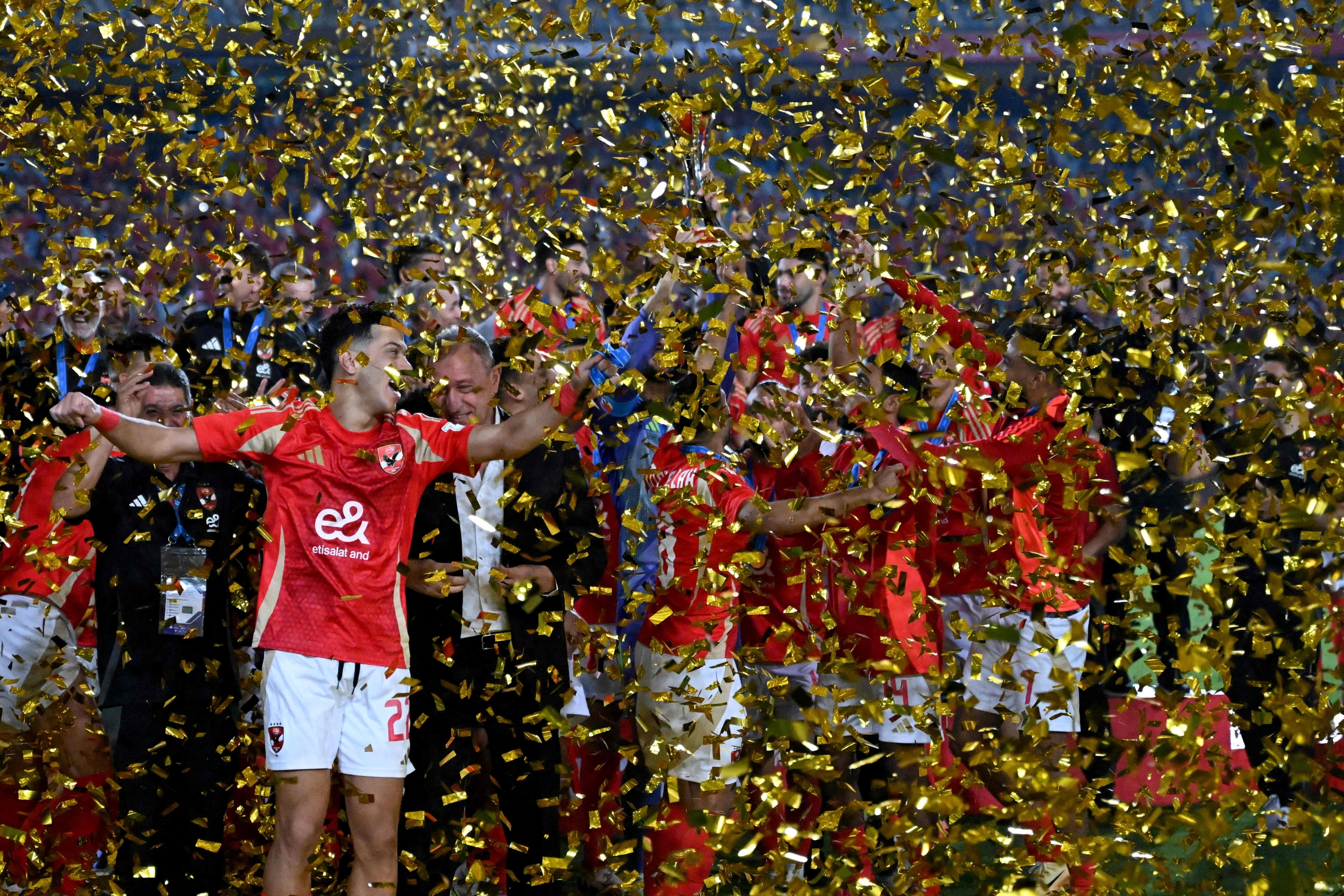 Egypts Ahly players celebrate with the trophy after their victory during the AfricanAsianPacific Cup football match, serving as the second round of the 2024 FIFA Intercontinental Cup, between Egypt's al-Ahly SC and the UAE's al-Ain FC at Cairo International Stadium in Cairo on October 29, 2024. (Photo by Khaled DESOUKI / AFP)