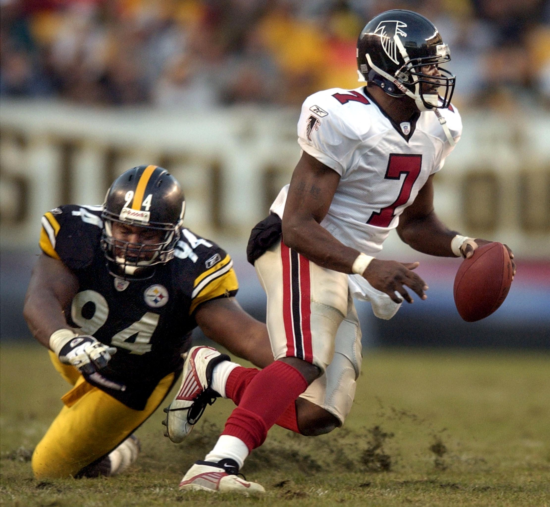 Atlanta Falcons quarterback Michael Vick (R) evades the tackle of Pittsburgh Steelers defender Rodney Bailey (L) during a fourth quarter touchdown run, 10 November, 2002 at Heinz Field in Pittsburgh, PA. The game ended in a 34-34 tie.  AFP PHOTO/DAVID MAXWELL (Photo by DAVID MAXWELL / AFP)