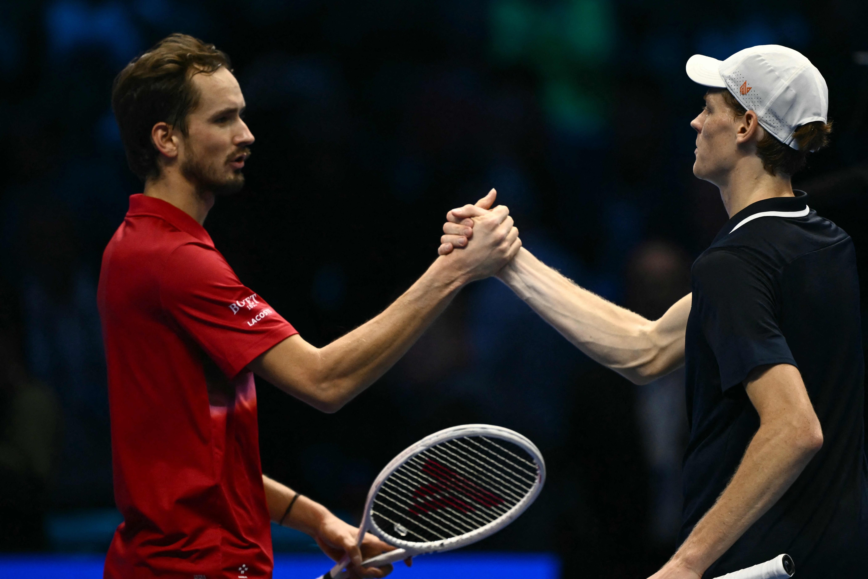 Italy's Jannik Sinner (R) shake hand with Russia's Daniil Medvedev after victory at the end of their match at the ATP Finals tennis tournament in Turin on November 14, 2024. (Photo by Marco BERTORELLO / AFP)