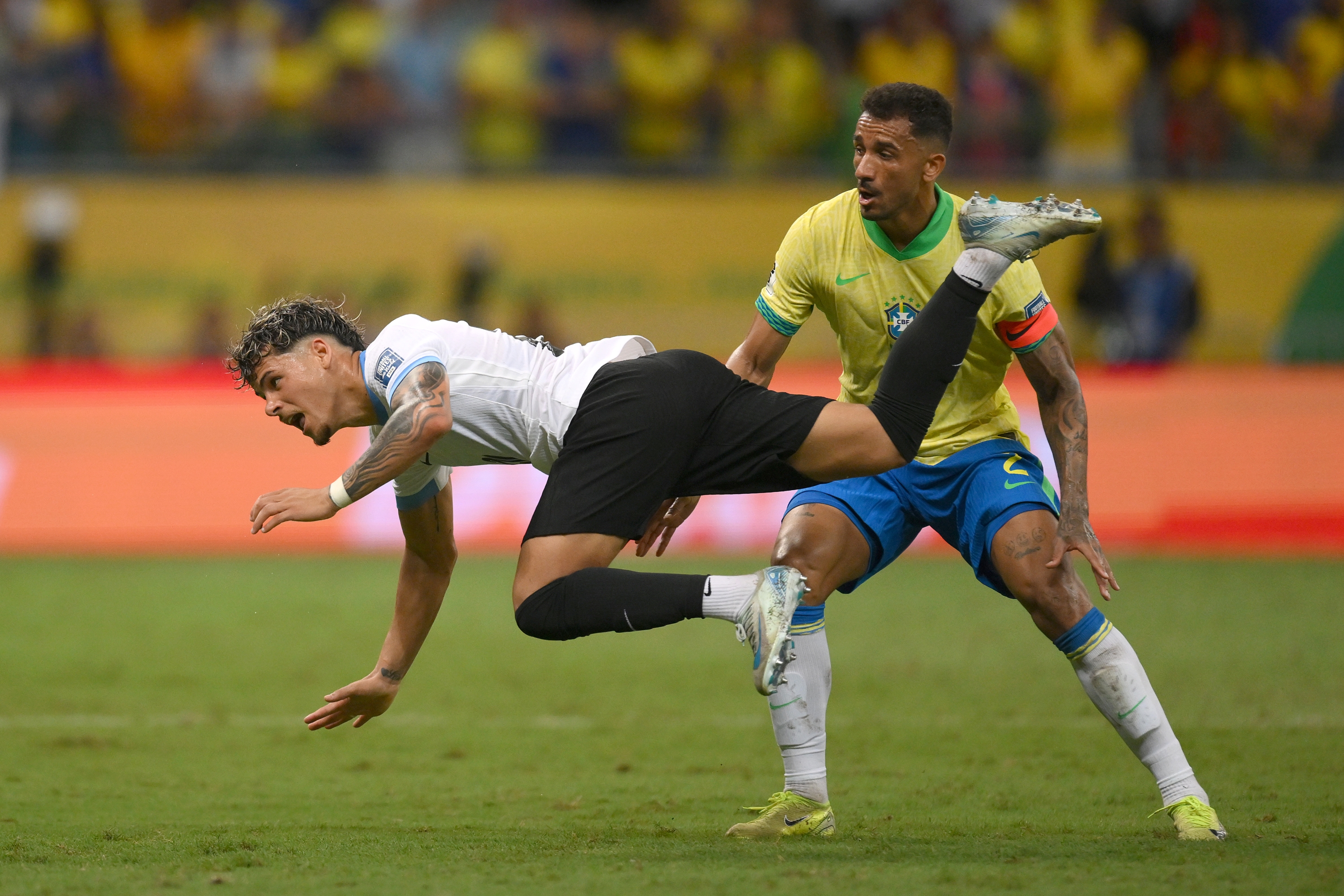 SALVADOR, BRAZIL - NOVEMBER 19: Maximiliano Araujo of Uruguay falls down over Danilo of Brazil during the South American FIFA World Cup 2026 Qualifier match between Brazil and Uruguay at Arena Fonte Nova on November 19, 2024 in Salvador, Brazil. (Photo by Pedro Vilela/Getty Images)