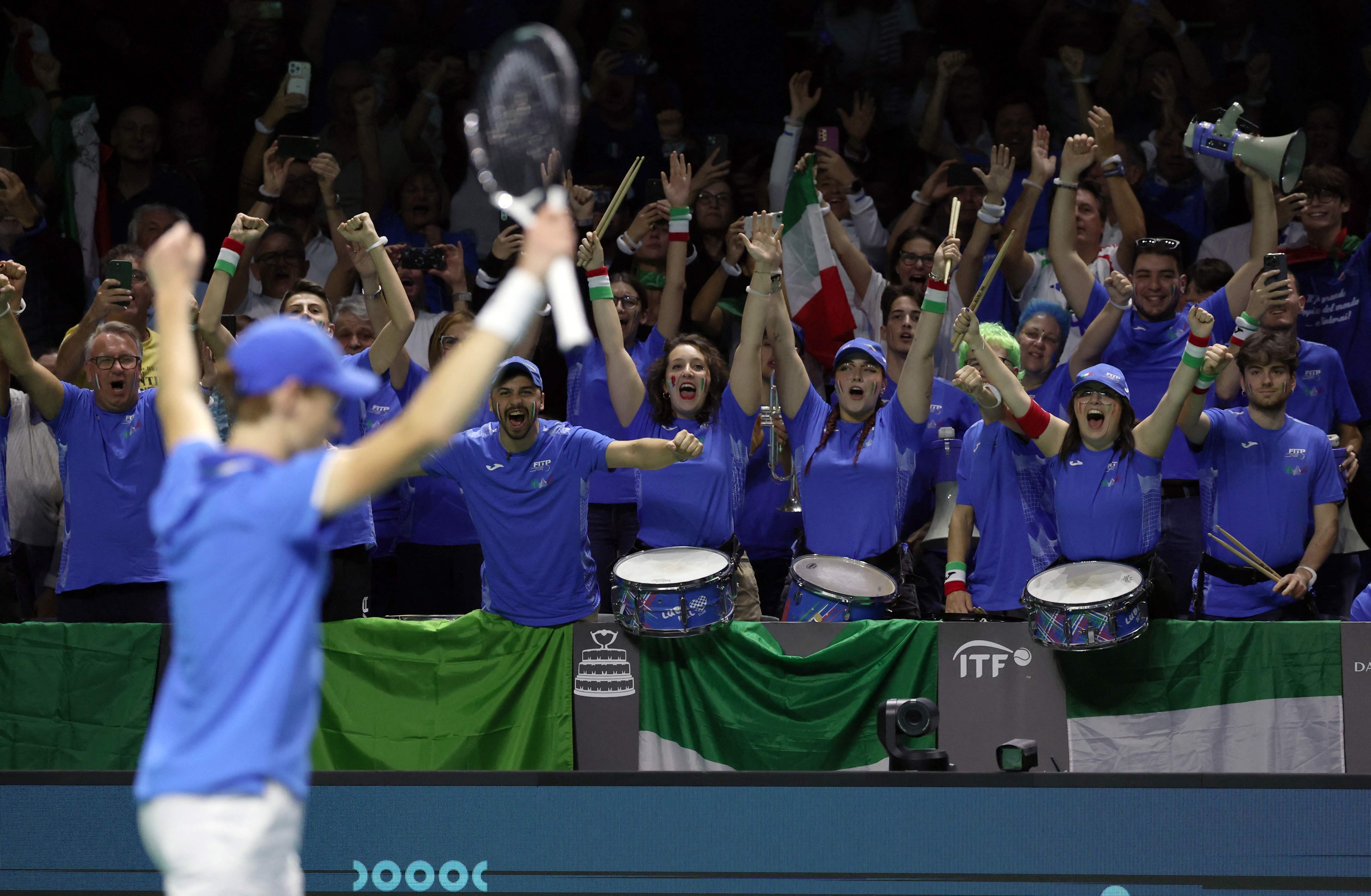 TOPSHOT - Italy fans celebrate Jannik Sinner's victory over Netherlands' Tallon Griekspoor during their final singles match between Italy and Netherlands at the Davis Cup Finals at the Palacio de Deportes Jose Maria Martin Carpena arena in Malaga, southern Spain, on November 24, 2024. (Photo by Thomas COEX / AFP)