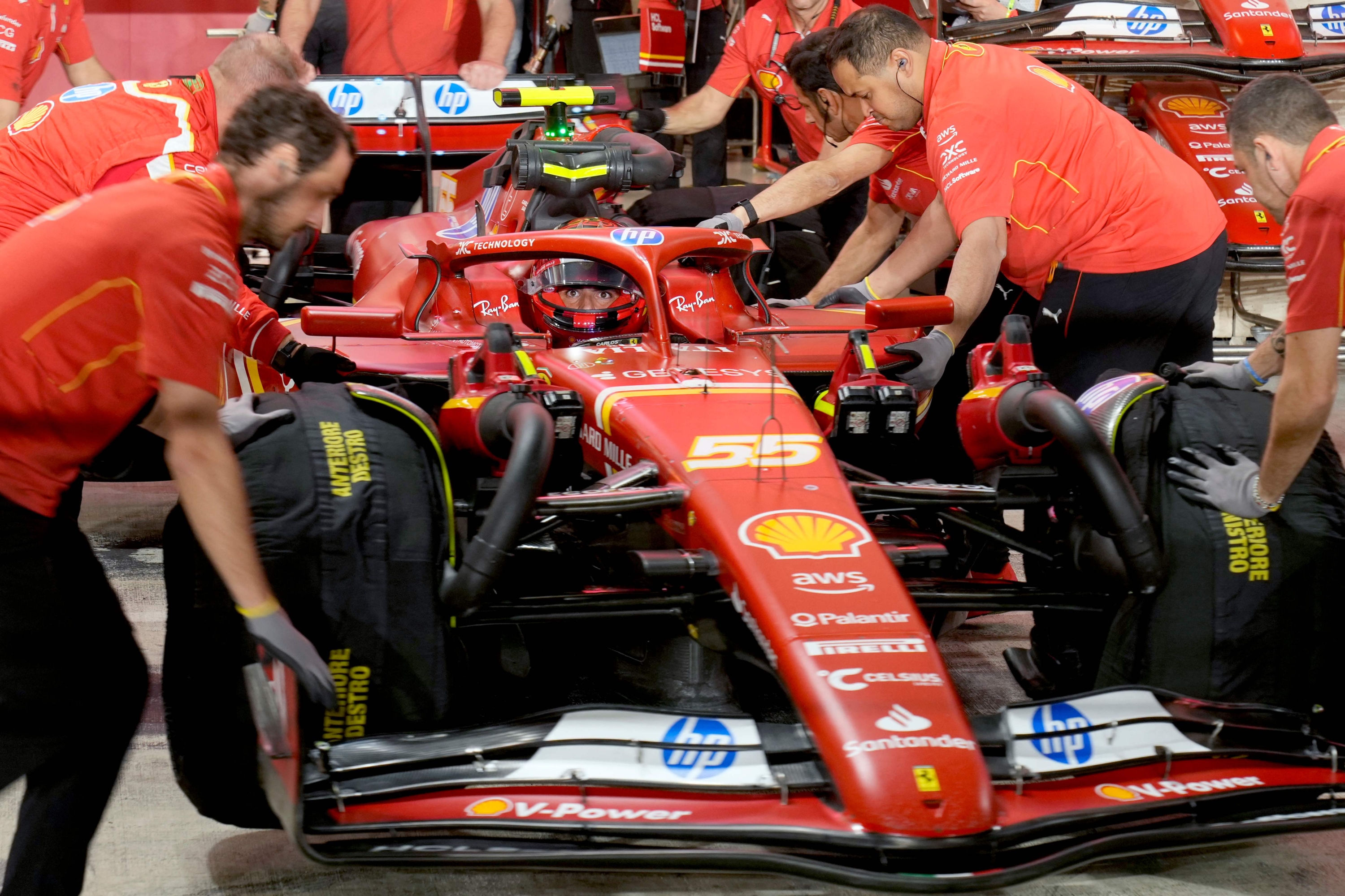 Mechanics push Ferrari's Spanish driver Carlos Sainz Jr. back into the pit during the sprint qualifying session ahead of the Qatari Formula One Grand Prix at the Lusail International Circuit in Lusail, north of Doha, on November 29, 2024. (Photo by Darko Bandic / POOL / AFP)