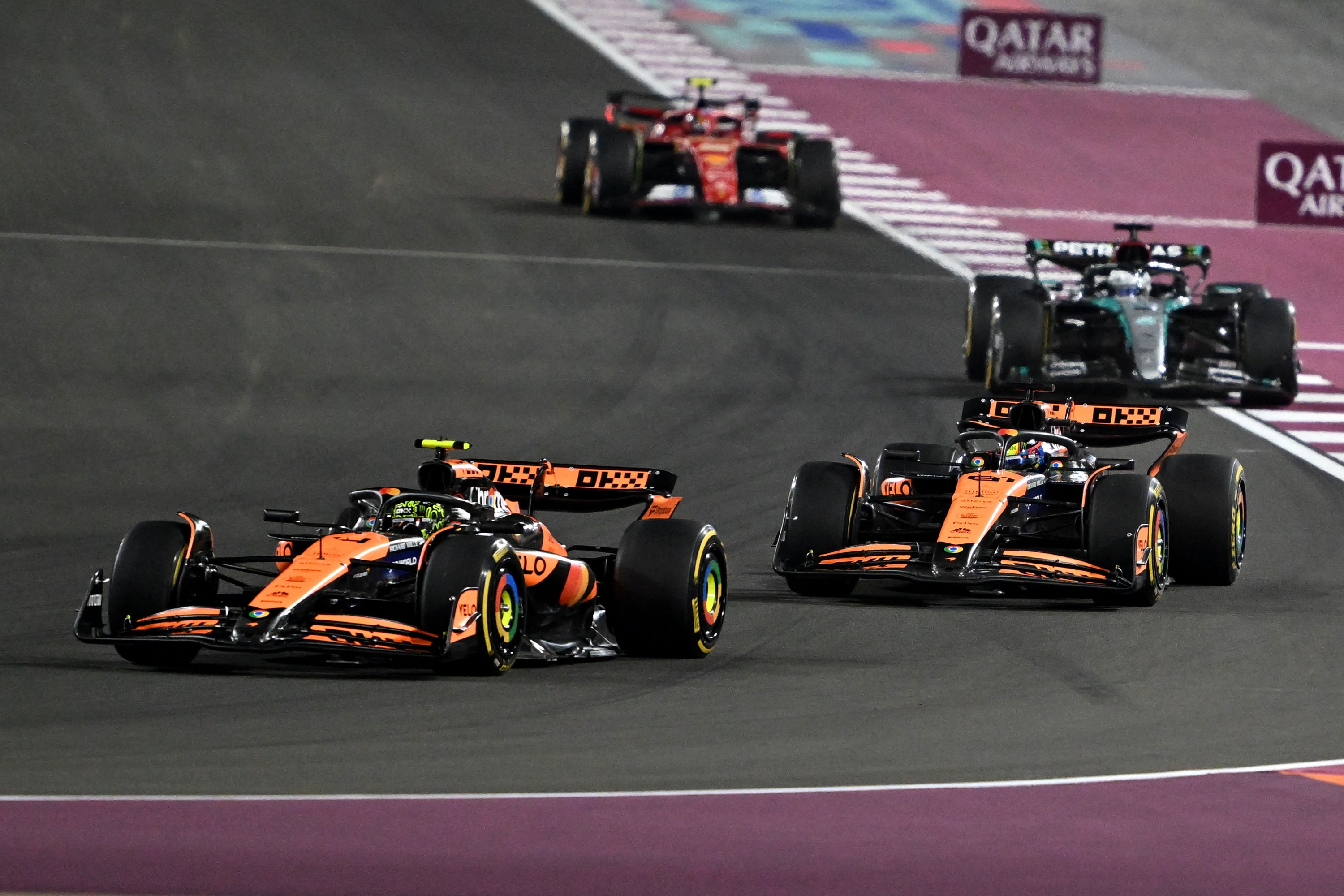 McLaren's British driver Lando Norris is followed by McLaren's Australian driver Oscar Piastri, Mercedes' British driver George Russell and Ferrari's Spanish driver Carlos Sainz Jr. during the sprint race ahead of the Qatari Formula One Grand Prix at the Lusail International Circuit in Lusail, north of Doha, on November 30, 2024. (Photo by Mahmud HAMS / AFP)