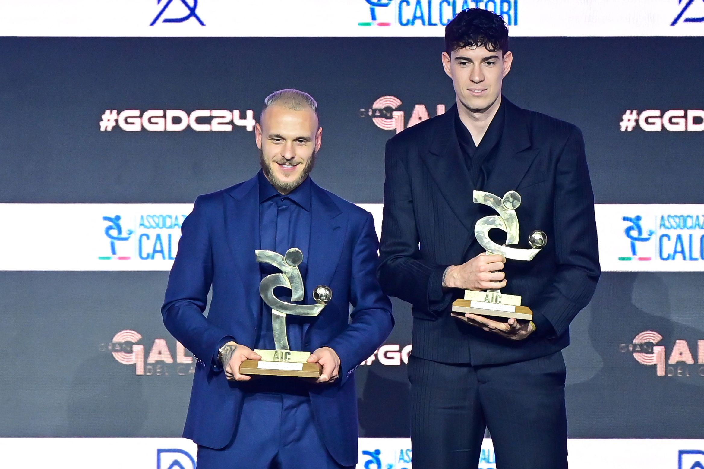 (L-R) Inter Milan's Italian defenders Federico Dimarco and Alessandro Bastoni, pose on stage after receiving their Best Defender of the Year award during the Italian Footballers' Association (AIC) gala and awards ceremony in Milan, on December 2, 2024. (Photo by Piero CRUCIATTI / AFP)