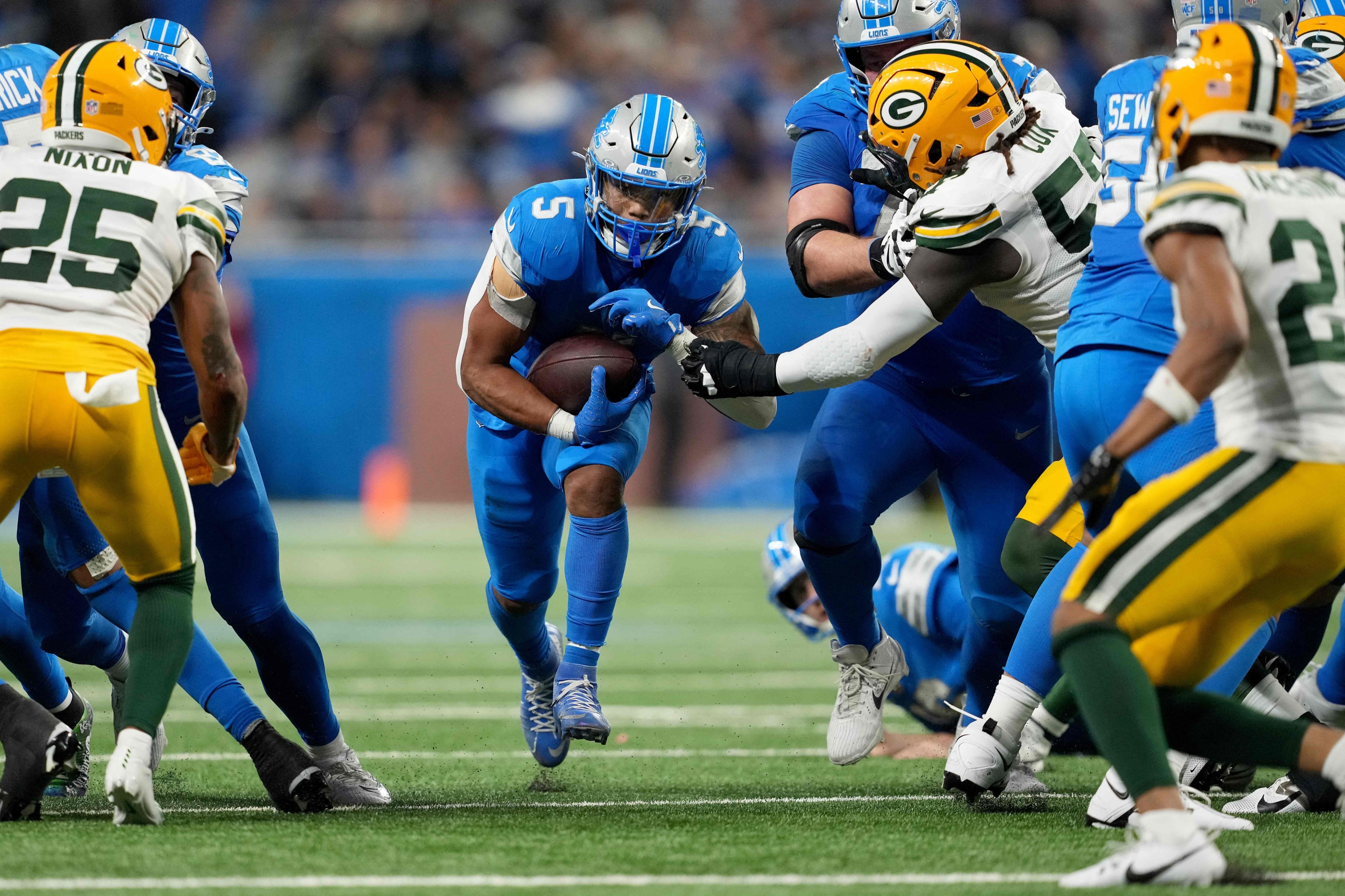 DETROIT, MICHIGAN - DECEMBER 05: David Montgomery #5 of the Detroit Lions runs the ball for a first down against the Green Bay Packers late in the fourth quarter of the game at Ford Field on December 05, 2024 in Detroit, Michigan.   Nic Antaya/Getty Images/AFP (Photo by Nic Antaya / GETTY IMAGES NORTH AMERICA / Getty Images via AFP)