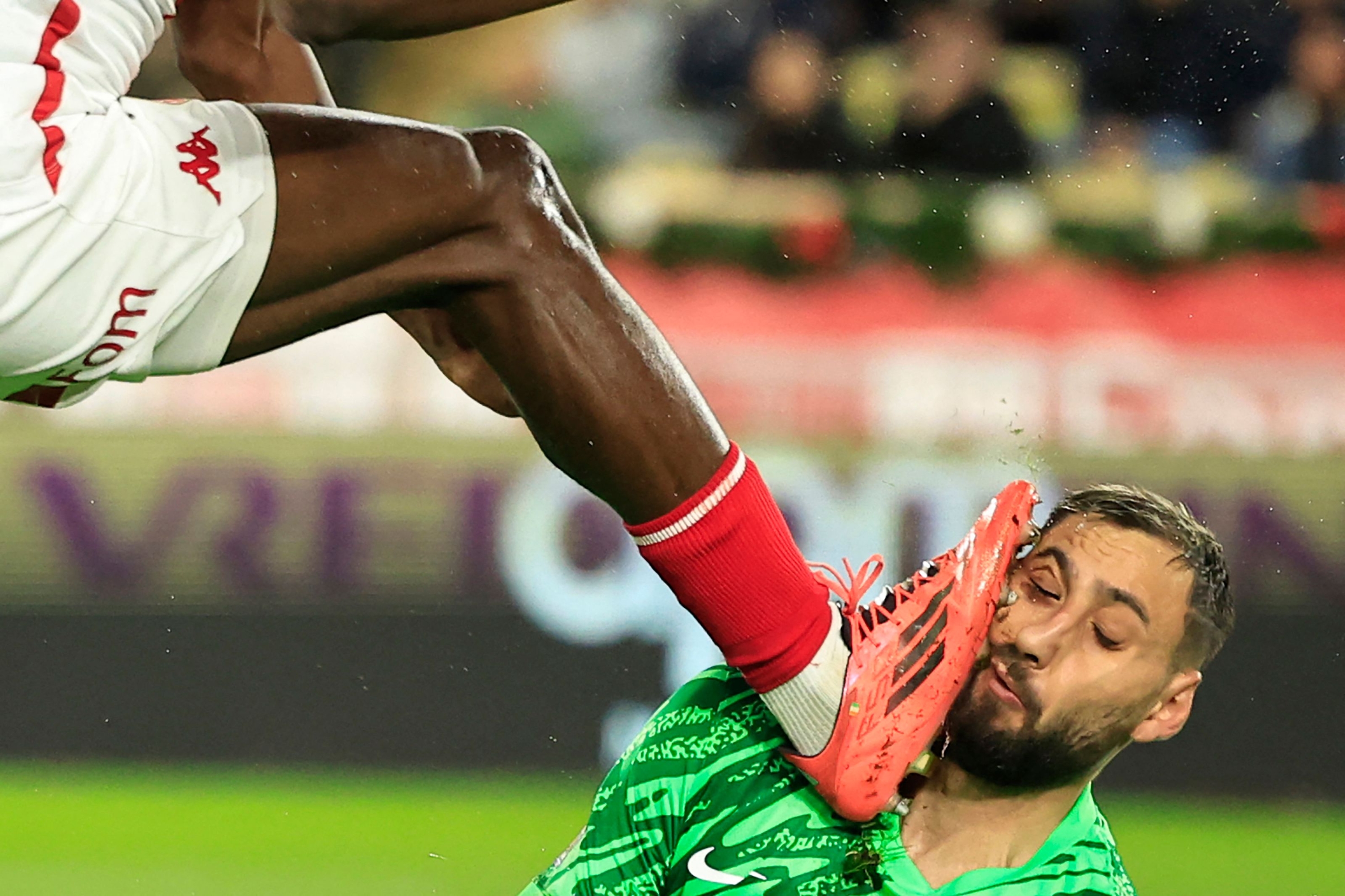 Paris Saint-Germain's Italian goalkeeper #01 Gianluigi Donnarumma sustains an injury by Monaco's Ivorian defender #17 Wilfried Singo (L) during the French L1 football match between AS Monaco and Paris Saint-Germain at the Louis II Stadium (Stade Louis II) in the Principality of Monaco on December 18, 2024. (Photo by Valery HACHE / AFP)