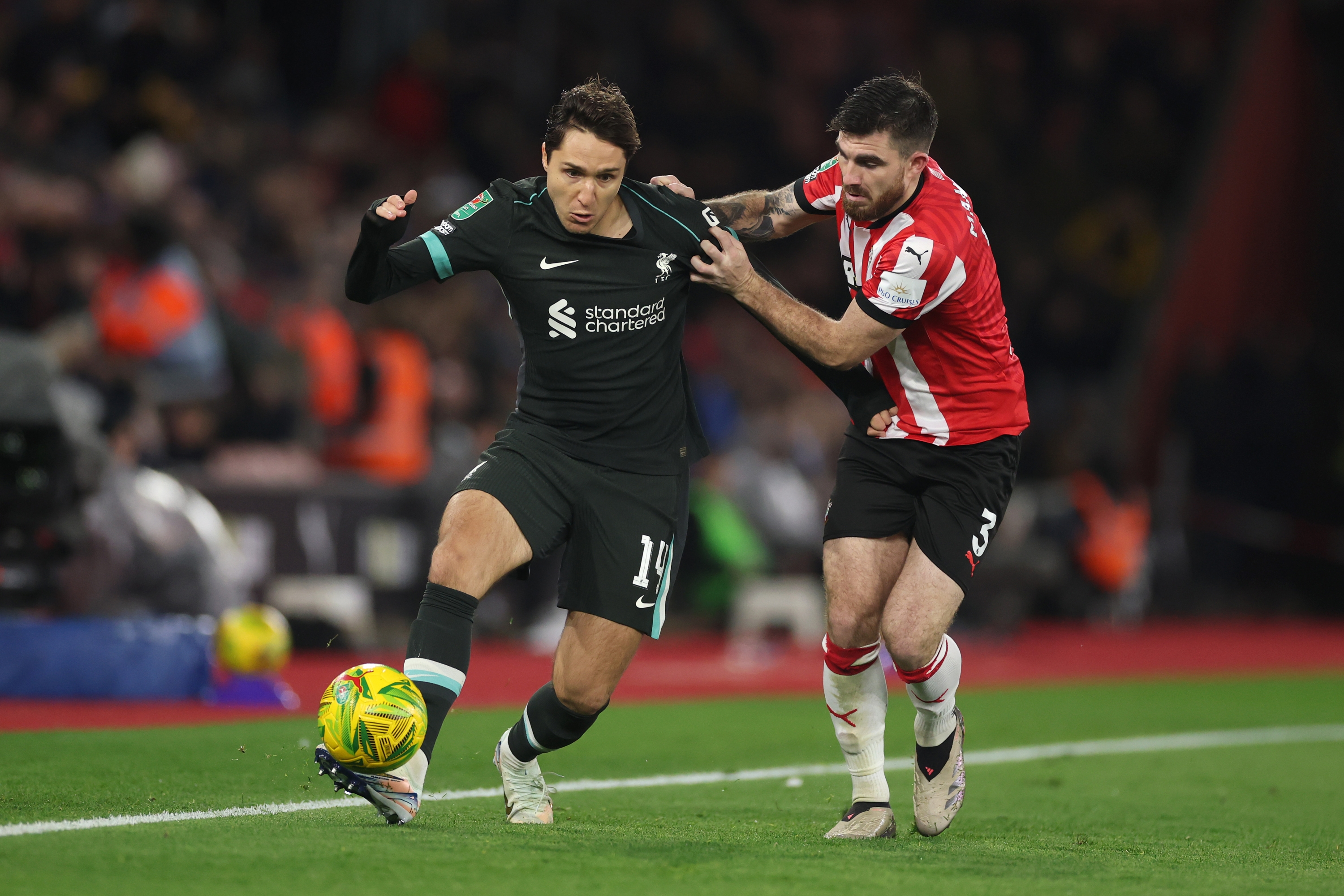 SOUTHAMPTON, ENGLAND - DECEMBER 18: Federico Chiesa of Liverpool is challenged by Ryan Manning of Southampton  during the Carabao Cup Quarter Final match between Southampton and Liverpool at St Mary's Stadium on December 18, 2024 in Southampton, England. (Photo by Michael Steele/Getty Images)