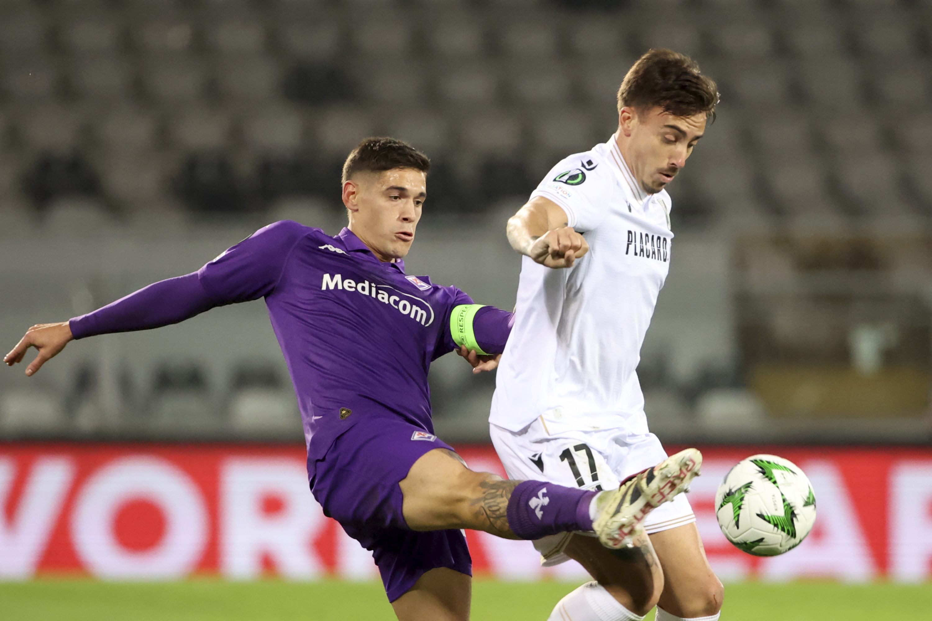 Fiorentina's Lucas Martinez Quarta vies for the ball with Vitoria's Joao Saraiva, right, during the Europa Conference League opening phase soccer match between Vitoria SC and Fiorentina at the D. Afonso Henriques stadium in Guimaraes, Portugal, Thursday, Dec. 19, 2024. (AP Photo/Luis Vieira)