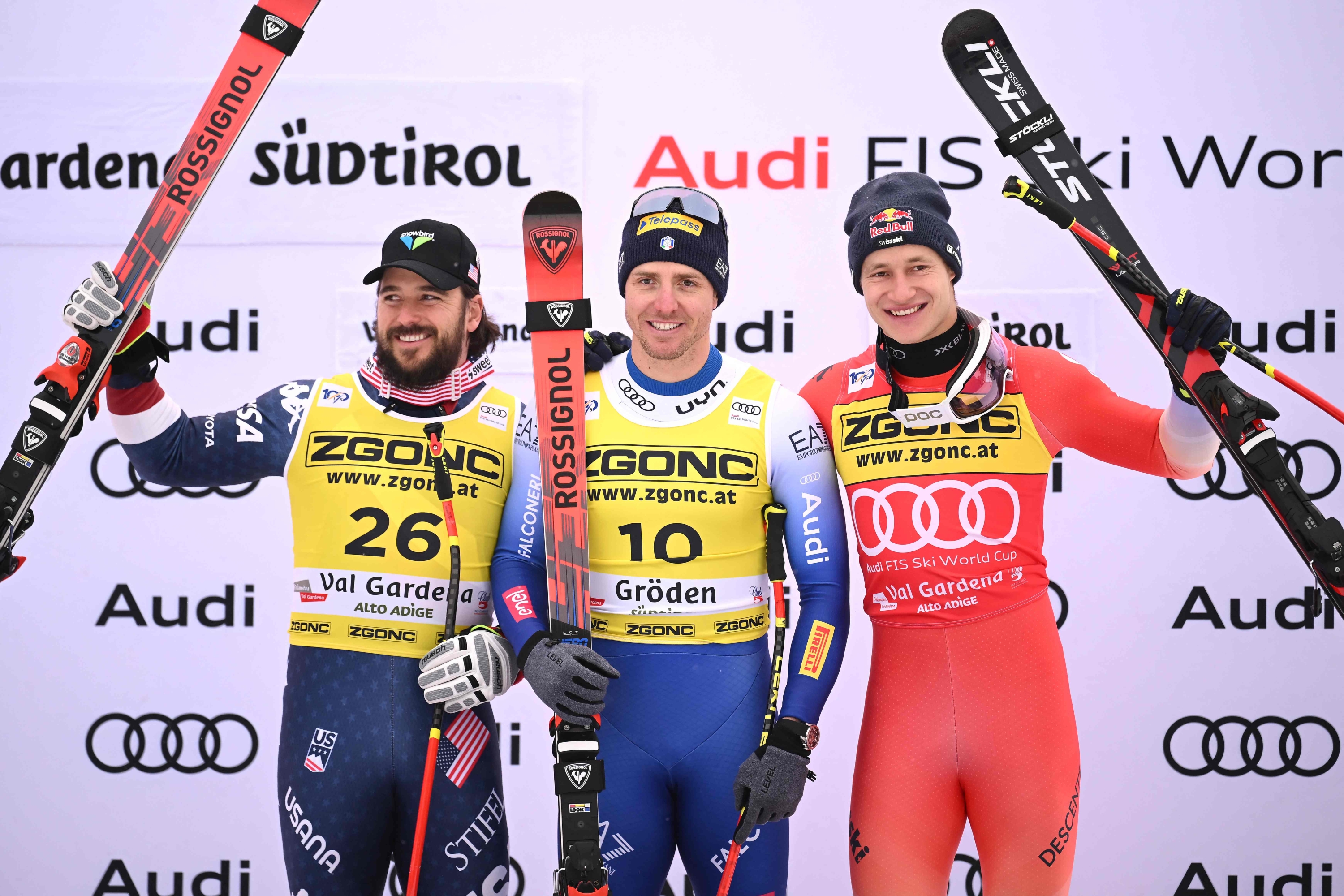 (FROM L) Second placed US Jared Goldberg, first placed Italy's Mattia Casse and third placed Switzerland's Marco Odermatt celebrate on the podium after the Men's Super-G race as part of the FIS Alpine ski World Cup 2024-2025, in Val Gardena on December 20, 2024. (Photo by Marco BERTORELLO / AFP)