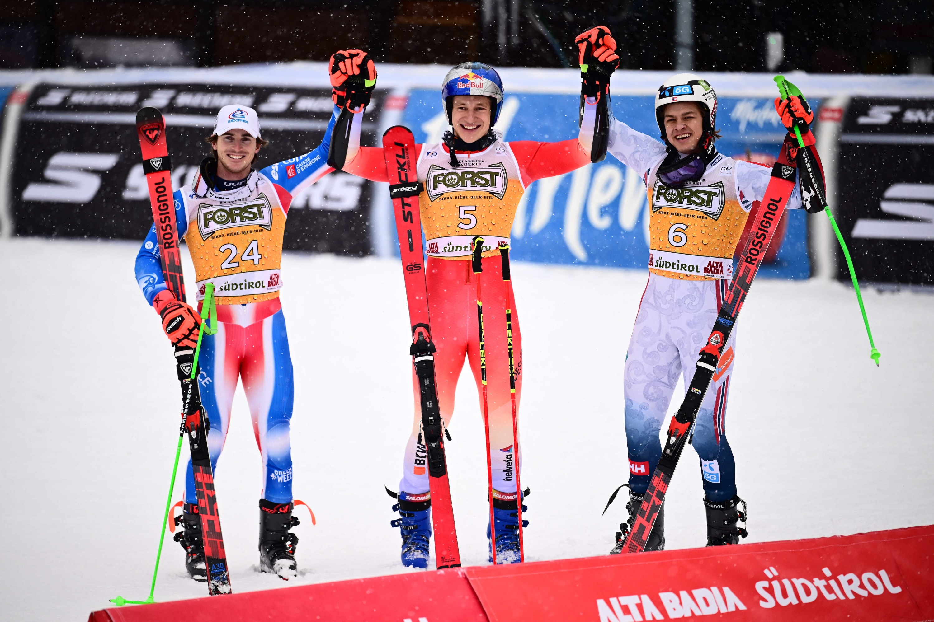 France's Leo Anguenot (L) second, Switzerland's Marco Odermatt (C) first, and Norway's Aleksander Steen Olsen, third, celebrate after winning the men's Giant Slalom, during the FIS Alpine Ski World Cup in Alta Badia on December 22, 2024. (Photo by Marco BERTORELLO / AFP)