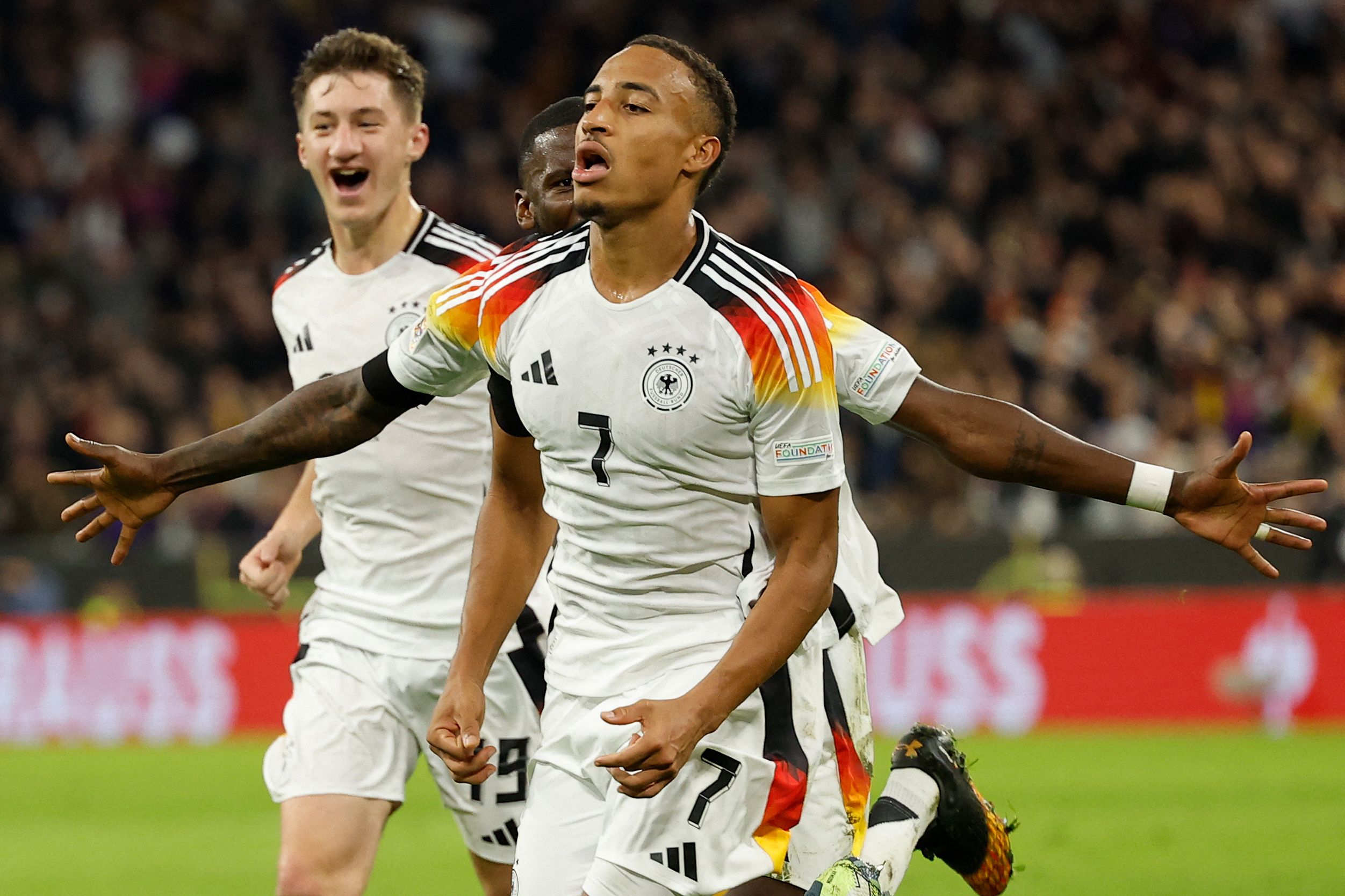 Germany's midfielder #07 Jamie Leweling celebrates scoring the opening goal with his teammates during the UEFA Nations League, League A Group A3 football match between Germany and the Netherlands in Munich, southern Germany on October 14, 2024. (Photo by Odd ANDERSEN / AFP)