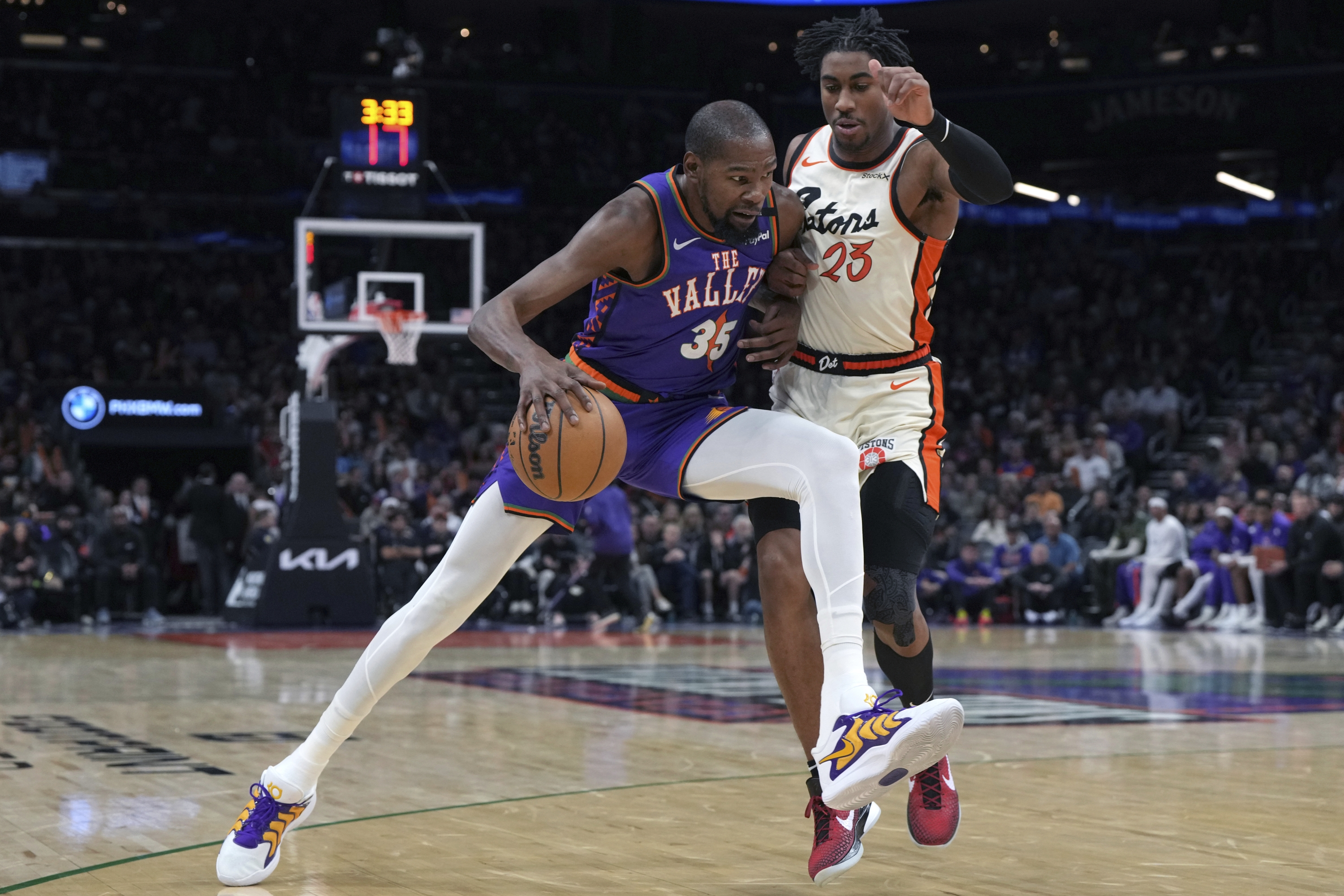 Phoenix Suns forward Kevin Durant (35) drives against Detroit Pistons guard Jaden Ivey, right, during the second half of an NBA basketball game, Saturday, Dec. 21, 2024, in Phoenix. (AP Photo/Rick Scuteri)