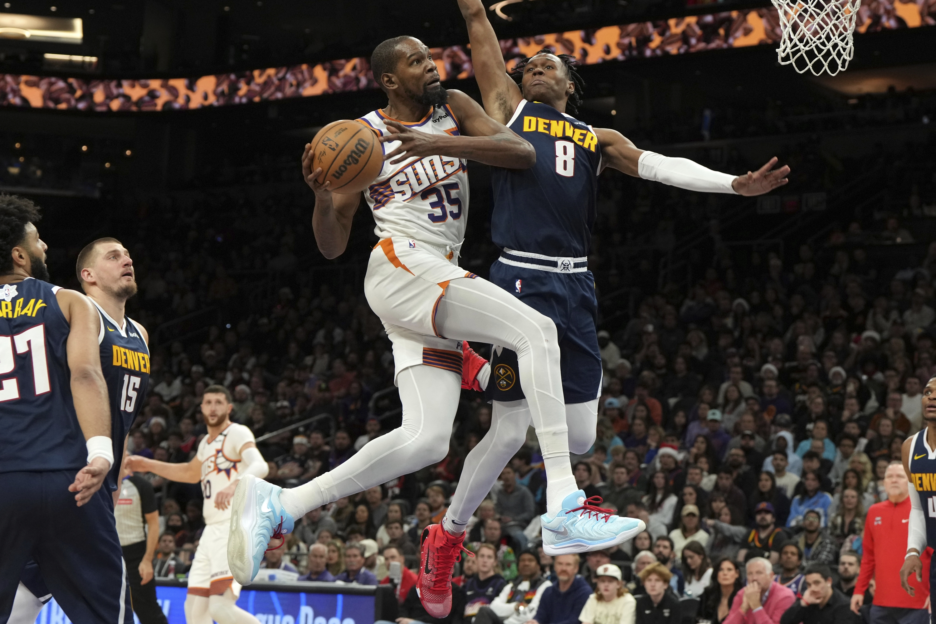 Phoenix Suns forward Kevin Durant (35) drives on Denver Nuggets forward Peyton Watson (8) during the second half of an NBA basketball game, Wednesday, Dec. 25, 2024, in Phoenix. Phoenix won 110-100. (AP Photo/Rick Scuteri)