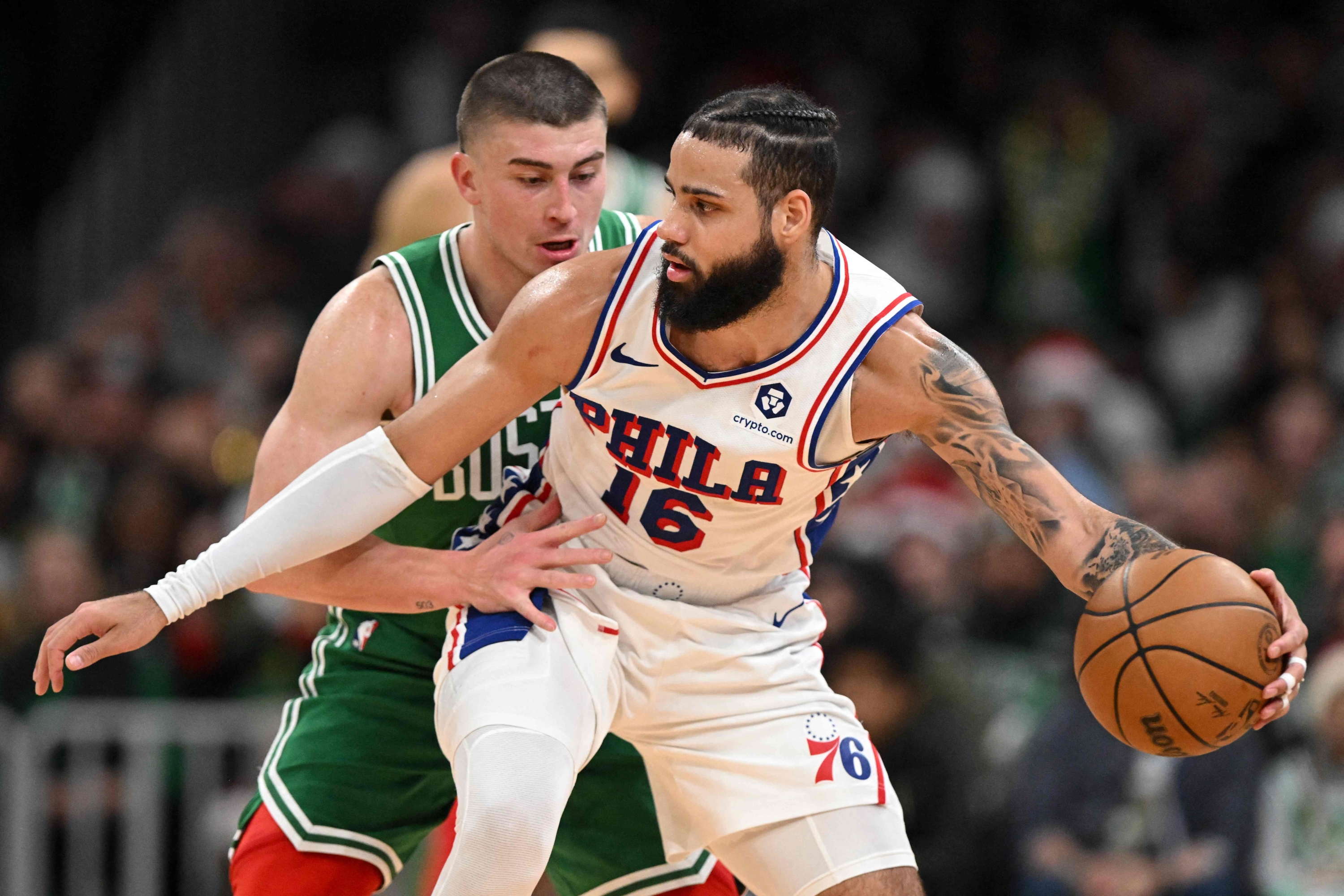 BOSTON, MASSACHUSETTS - DECEMBER 25: Caleb Martin #16 of the Philadelphia 76ers drives to the basket against Payton Pritchard #11 of the Boston Celticsduring the fourth quarter at the the TD Garden on December 25, 2024 in Boston, Massachusetts. NOTE TO USER: User expressly acknowledges and agrees that, by downloading and or using this photograph, User is consenting to the terms and conditions of the Getty Images License Agreement.   Brian Fluharty/Getty Images/AFP (Photo by Brian Fluharty / GETTY IMAGES NORTH AMERICA / Getty Images via AFP)