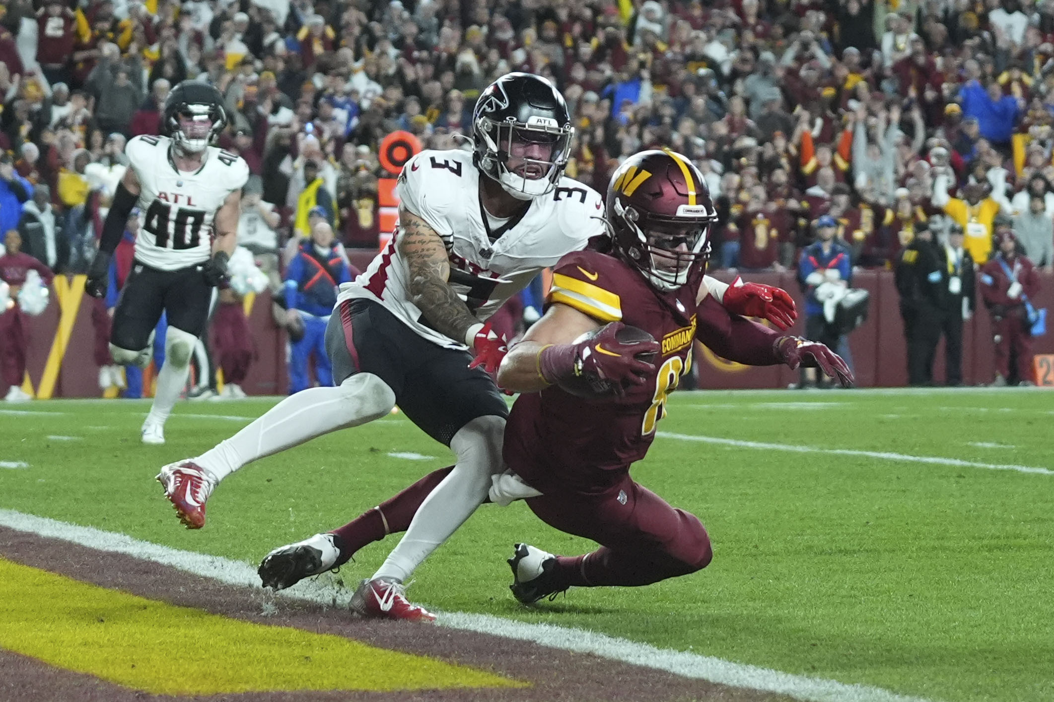 Washington Commanders tight end Zach Ertz scores on a touchdown reception against Atlanta Falcons safety Jessie Bates III (3) during the second half of an NFL football game, Sunday, Dec. 29, 2024, in Landover, Md. (AP Photo/Stephanie Scarbrough)