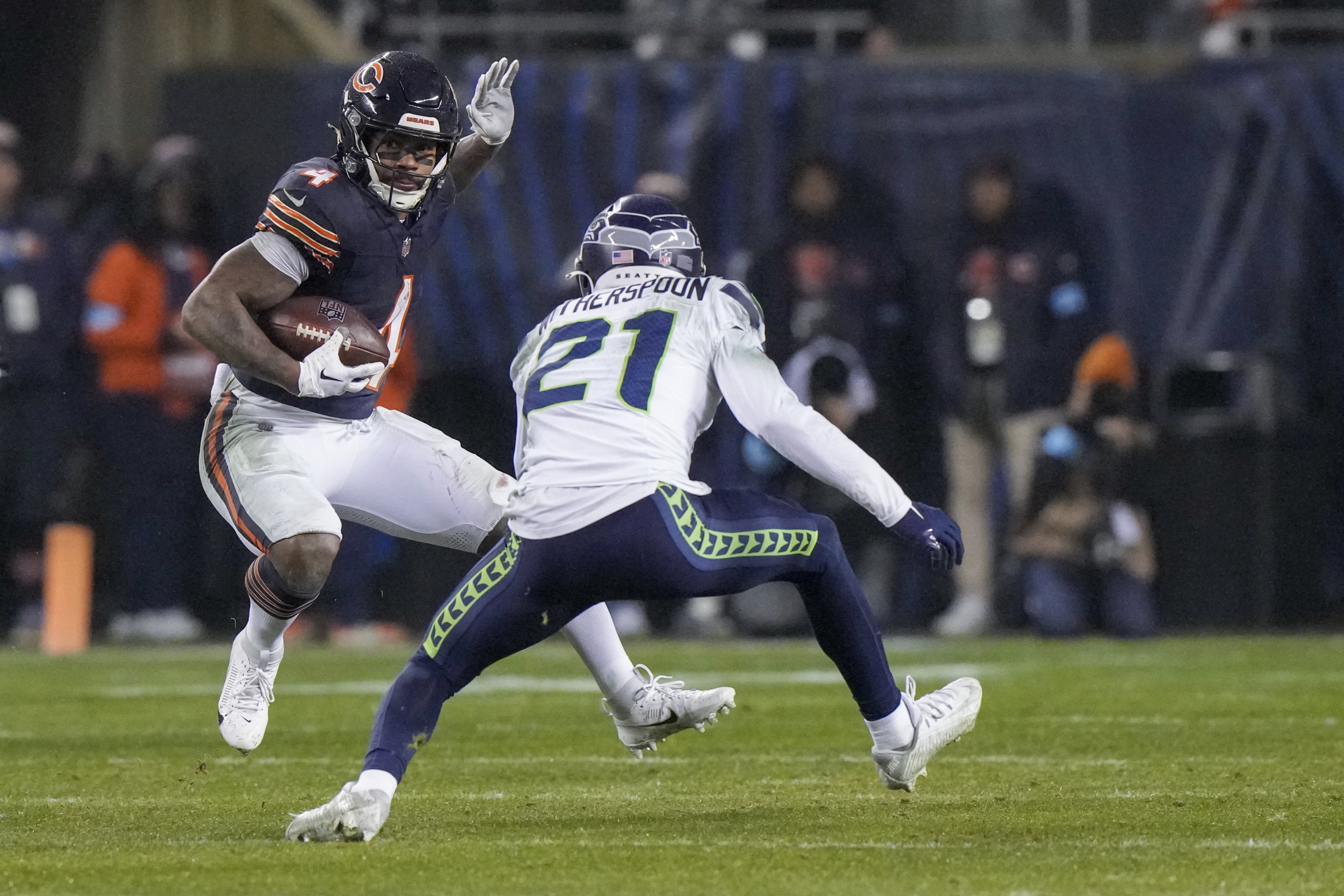 Chicago Bears running back D'Andre Swift, left, runs with the ball as Seattle Seahawks cornerback Devon Witherspoon defends during the second half of an NFL football game, Thursday, Dec. 26, 2024, in Chicago. (AP Photo/Nam Y. Huh)