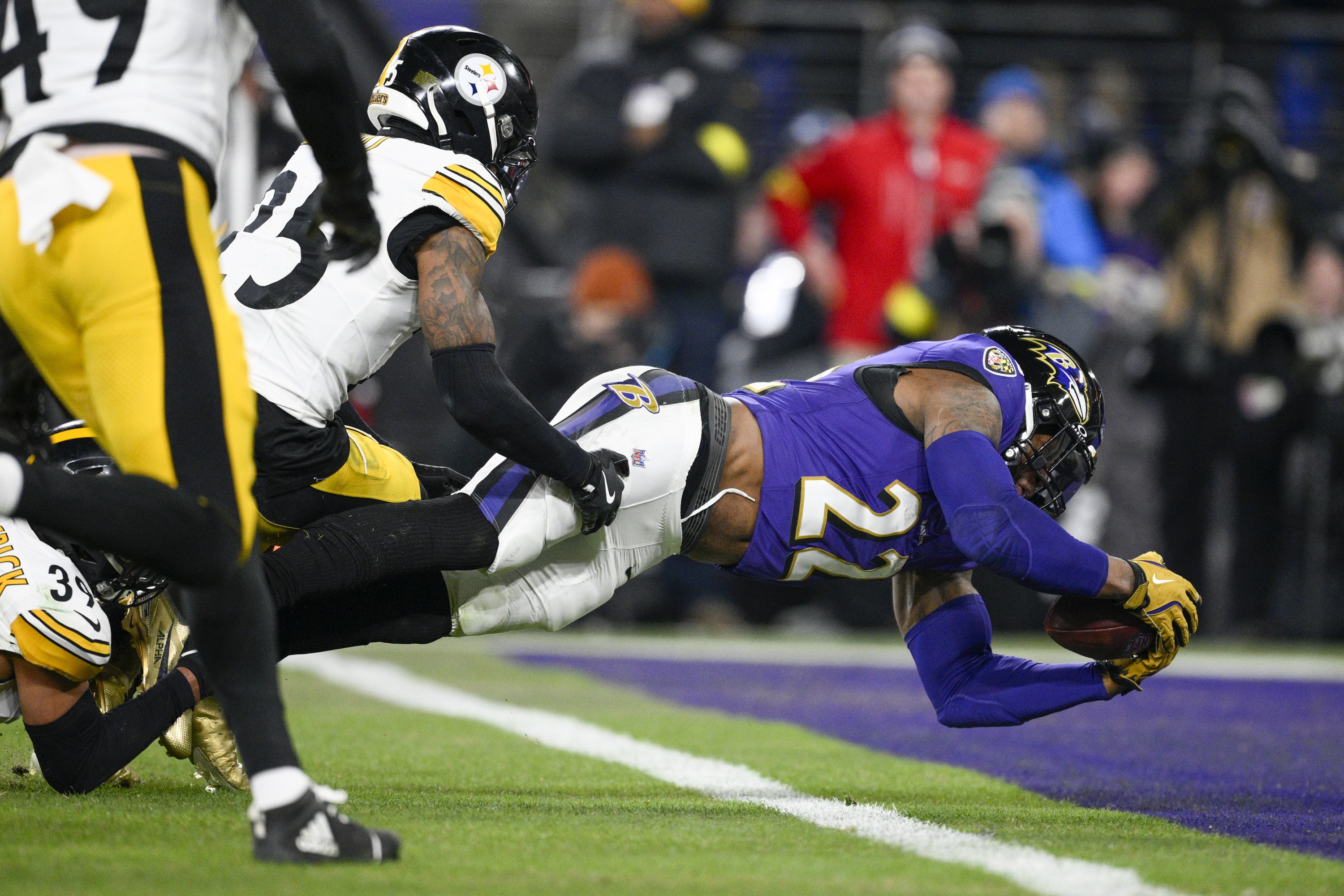 Baltimore Ravens running back Derrick Henry, right, dives across the goal line to scoring a touchdown in front of Pittsburgh Steelers safety DeShon Elliott (25) during the first half of an NFL wild-card playoff football game, Saturday, Jan. 11, 2025, in Baltimore. (AP Photo/Nick Wass)