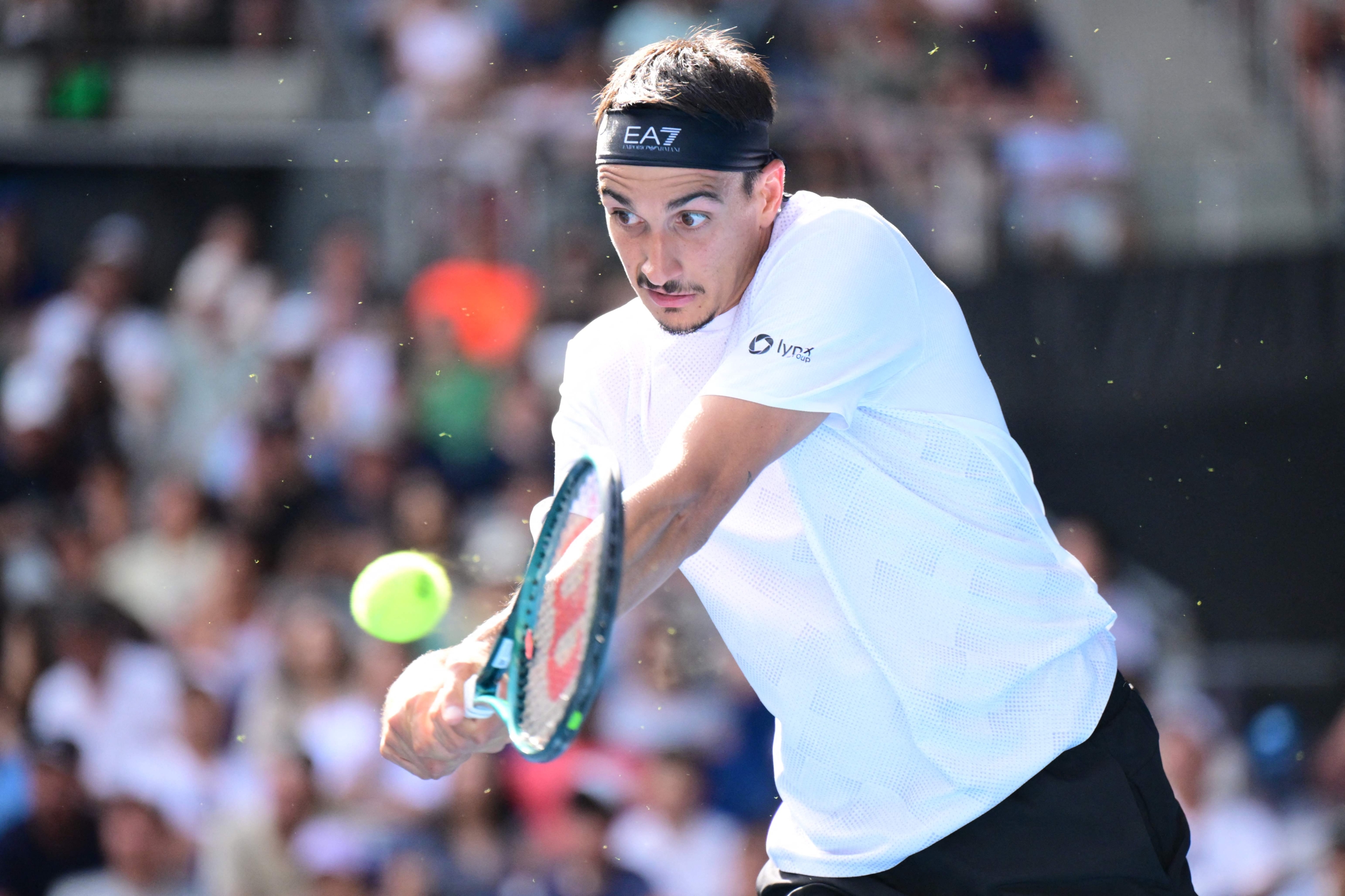 Italy's Lorenzo Sonego hits a return against USA's Learner Tien during their men's singles match on day nine of the Australian Open tennis tournament in Melbourne on January 20, 2025. (Photo by Yuichi YAMAZAKI / AFP) / -- IMAGE RESTRICTED TO EDITORIAL USE - STRICTLY NO COMMERCIAL USE --