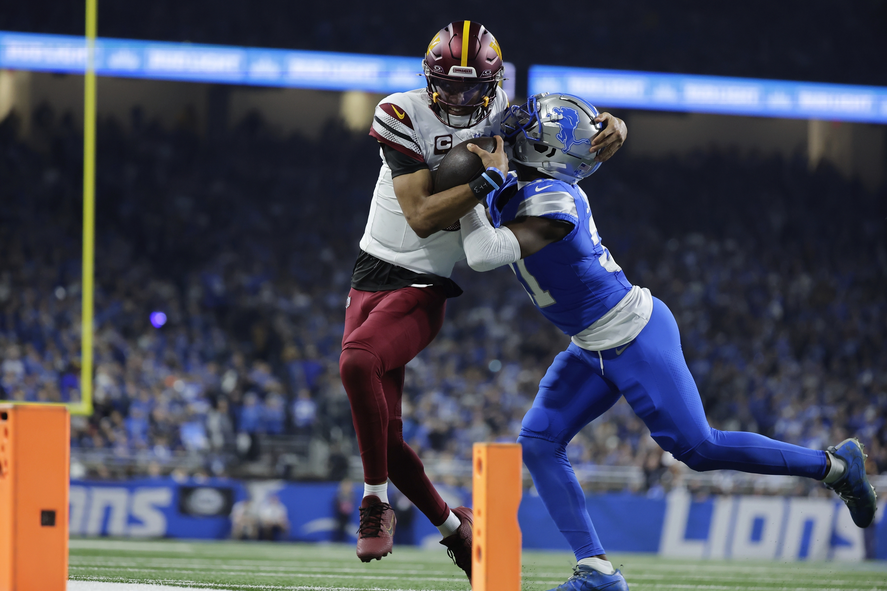 Detroit Lions safety Kerby Joseph (31) pushes Washington Commanders quarterback Jayden Daniels (5) out of bounds during the first half of an NFL football divisional playoff game, Saturday, Jan. 18, 2025, in Detroit. (AP Photo/Rey Del Rio)