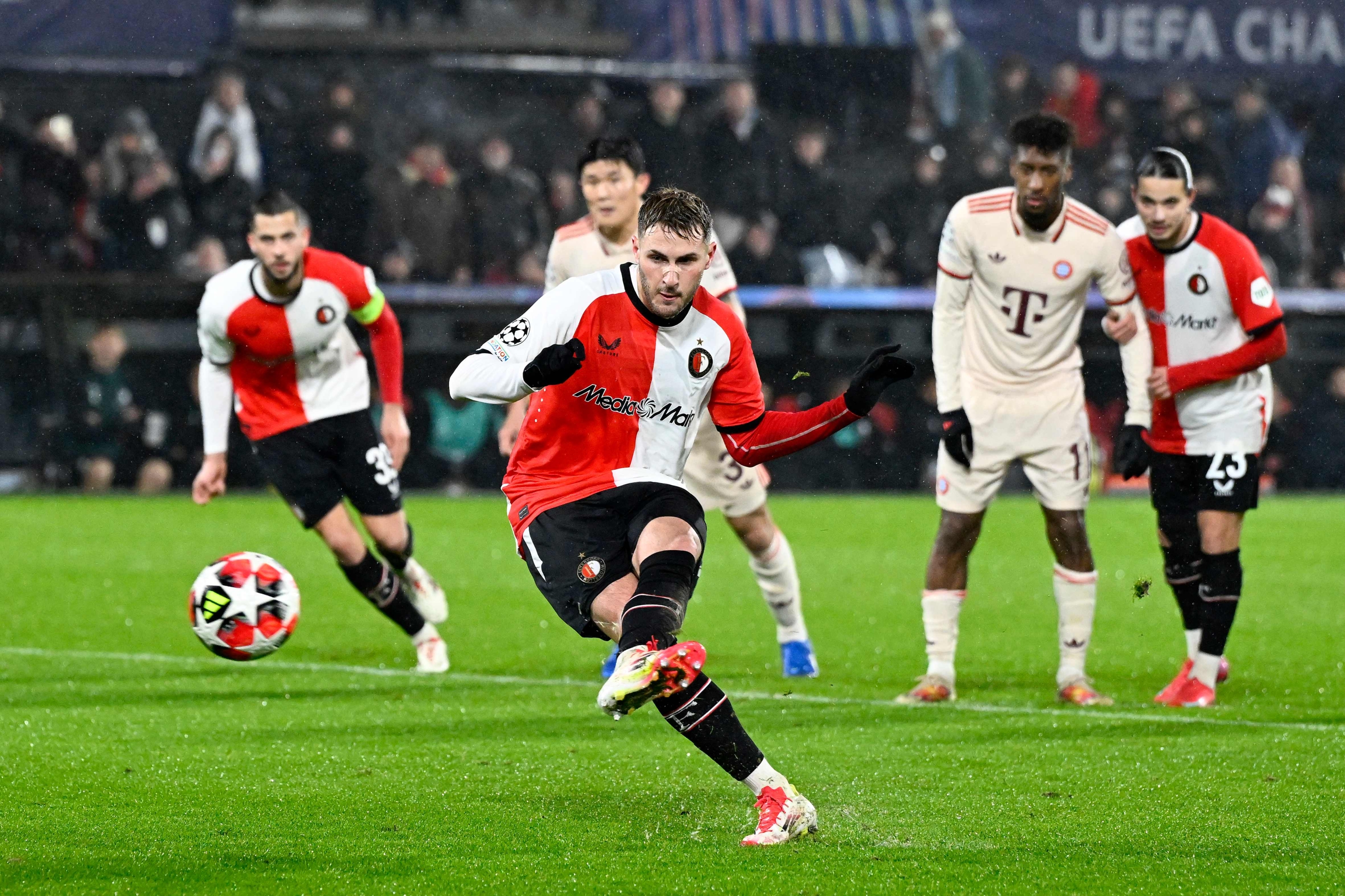 TOPSHOT - Feyenoord's Mexican forward #29 Santiago Gimenez (C) shoots to score a penalty and Feyenoord's second goal during the UEFA Champions League, league phase day 7, football match between Feyenoord (NED) and FC Bayern Munich (GER) at the Feyenoord Stadium in Rotterdam, on January 22, 2025. (Photo by JOHN THYS / AFP)