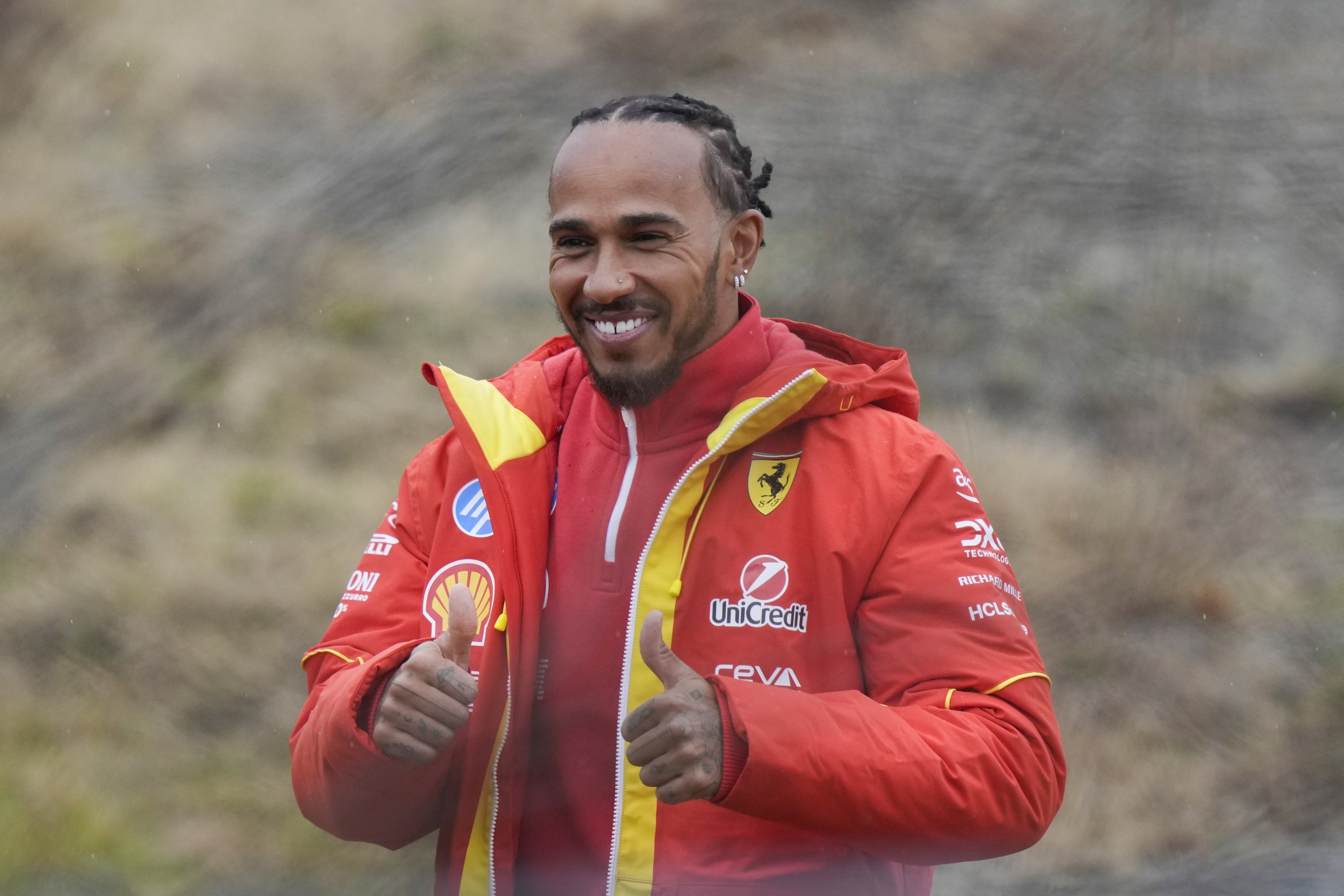 British driver Lewis Hamilton cheers Ferrari fans gathered outside the track, after testing a Ferrari Formula One SF-23, in Fiorano Modenese, Italy, Wednesday, Jan.22, 2025. (AP Photo/Luca Bruno)