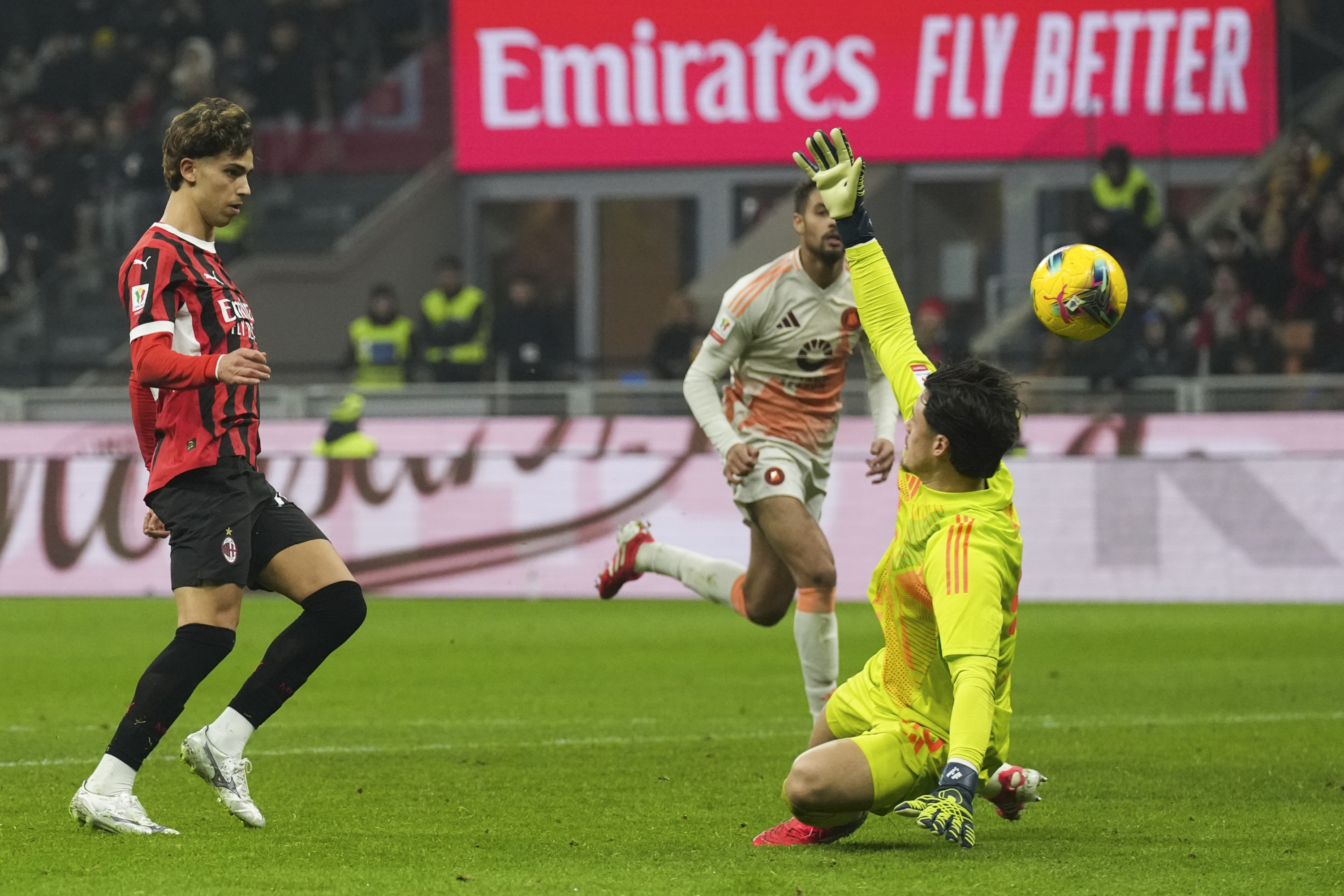 AC Milan's Joao Felix, left, scores his side's third goal during an Italian Cup quarterfinal soccer match between AC Milan and Roma at the San Siro stadium, in Milan, Italy, Wednesday, Feb. 5, 2025. (AP Photo/Antonio Calanni)