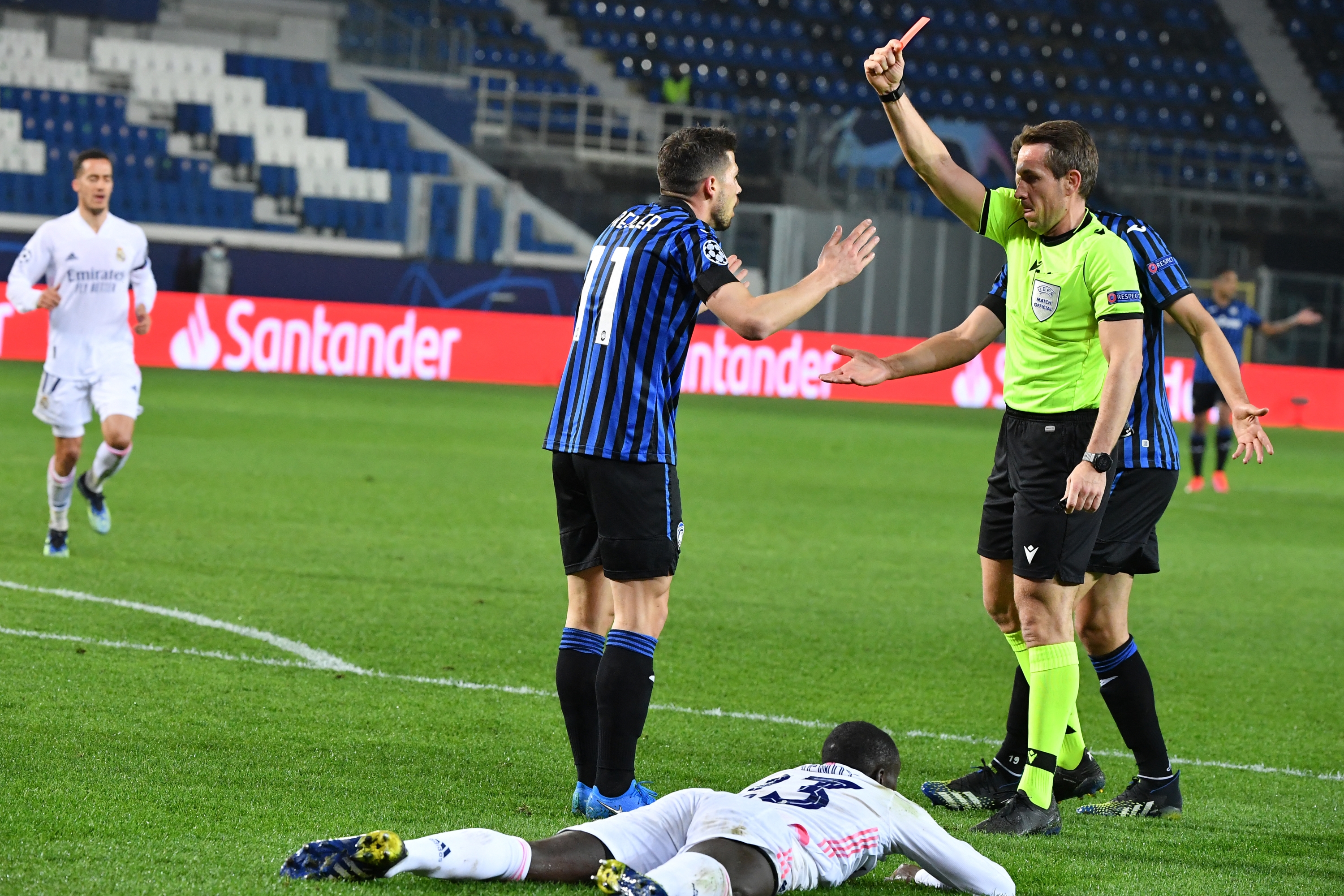 German referee Tobias Stieler gives a red card to Atalanta's Swiss midfielder Remo Freuler during the UEFA Champions League round of 16 first leg football match Atalanta vs Real Madrid on February 24, 2021 at the Atleti Azzurri d'Italia stadium in Bergamo. (Photo by Tiziana FABI / AFP)