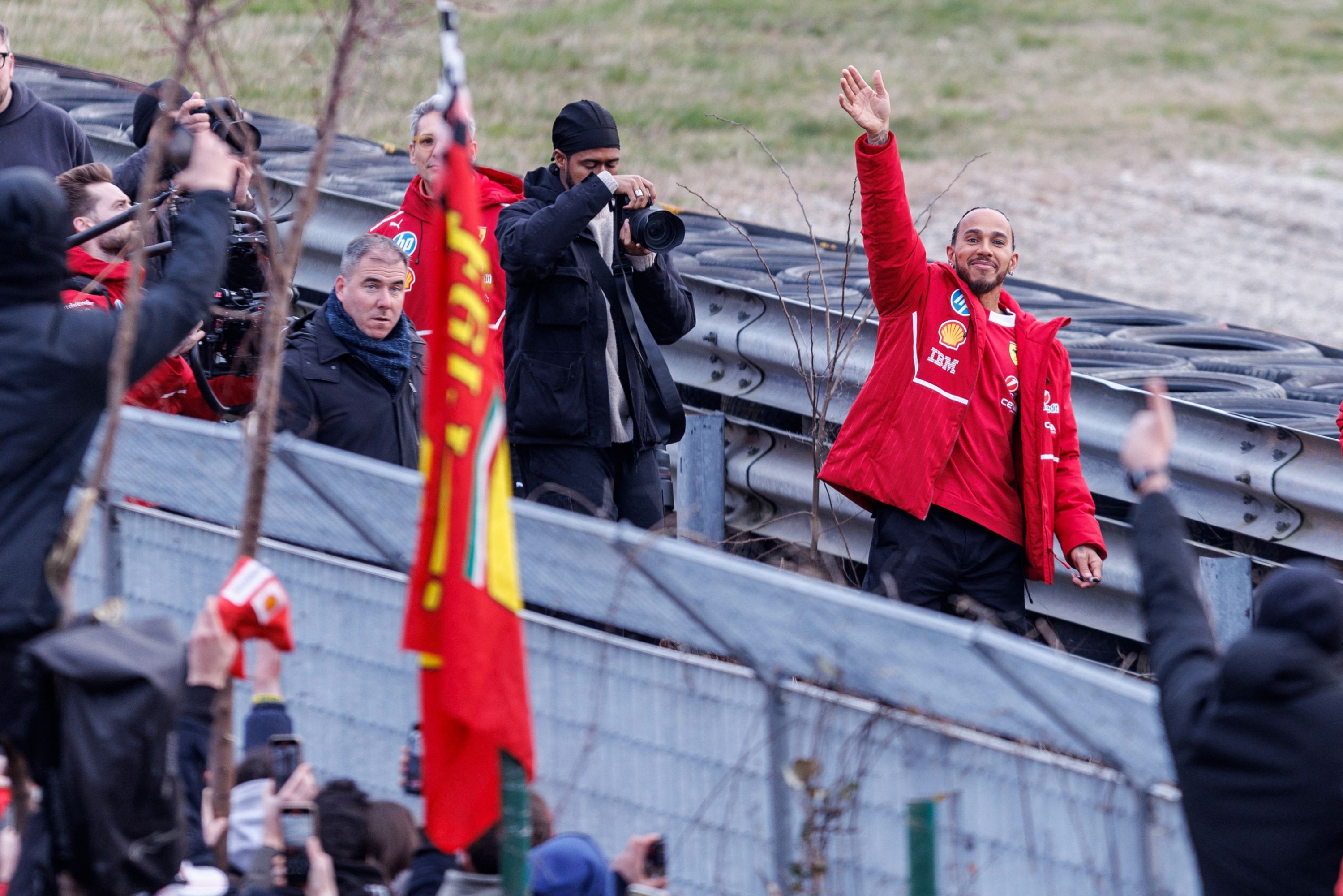 TOPSHOT - British F1 driver Lewis Hamilton waves to fans after he tried the new F1 Ferrari SF-25 during tests at Fiorano Circuit on February 19, 2025 in Fiorano Modenese near Maranello. (Photo by Federico SCOPPA / AFP)