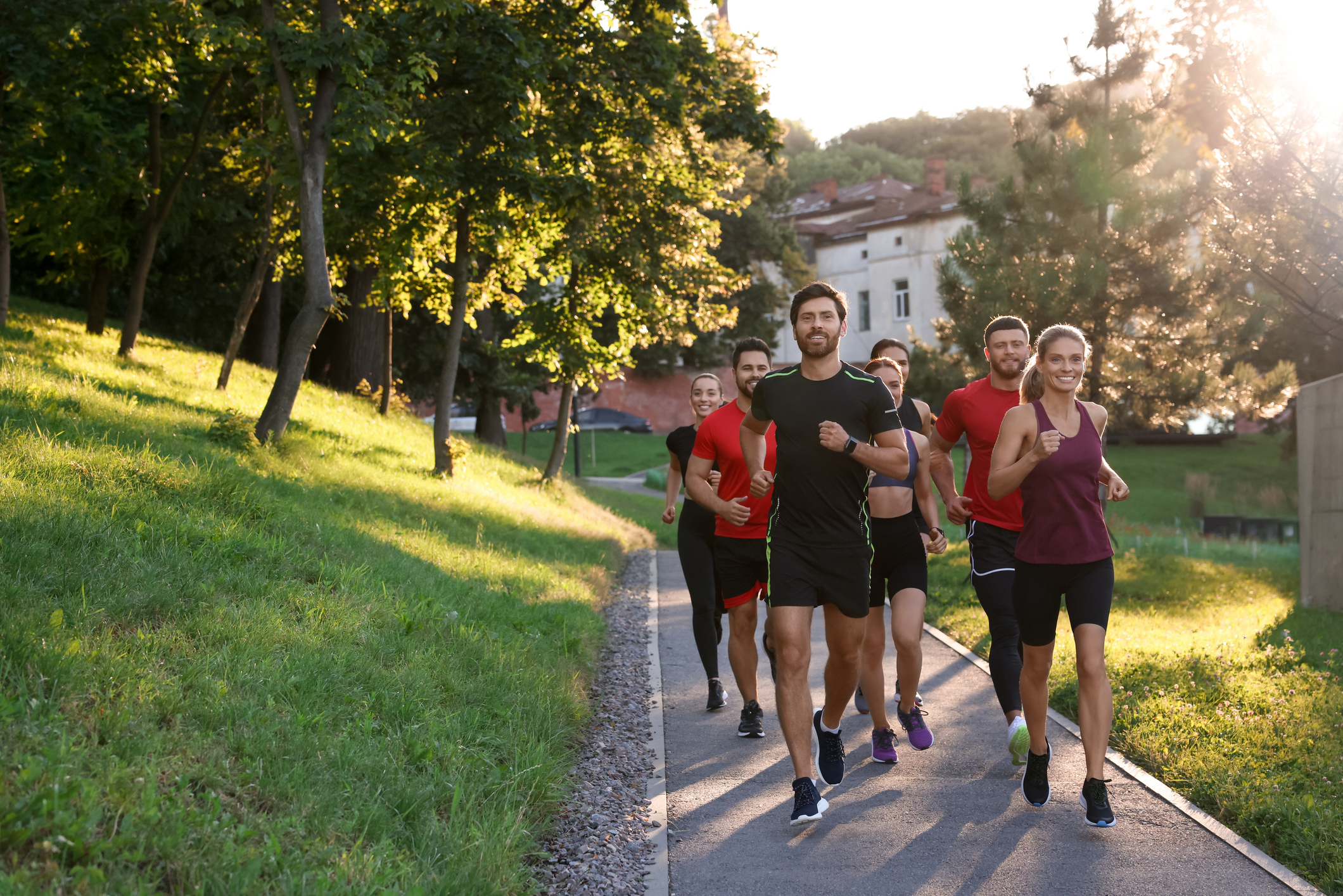 Group of people running outdoors on sunny day. Space for text