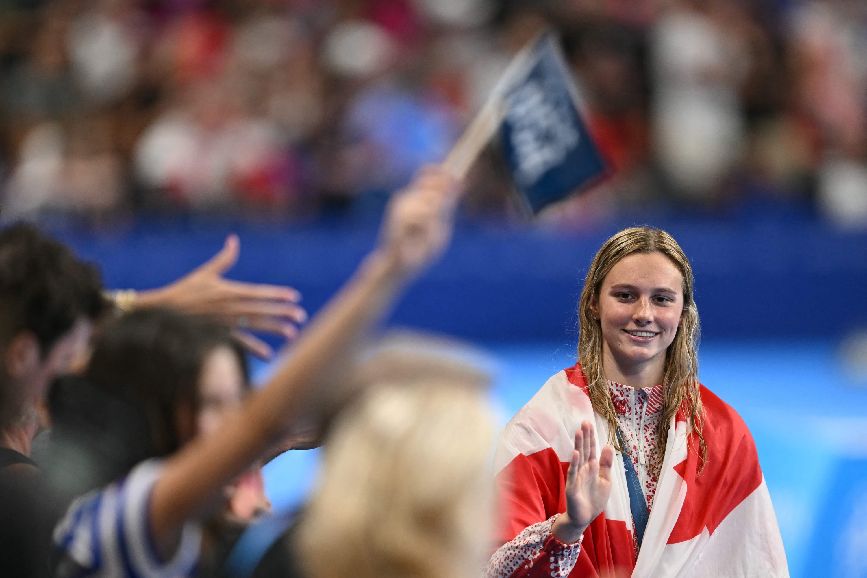 (FILES) Gold medallist Canada's Summer Mcintosh celebrates during the podium ceremony of the women's 200m individual medley swimming event during the Paris 2024 Olympic Games at the Paris La Defense Arena in Nanterre, west of Paris, on August 3, 2024. Canada's Summer Mcintosh moved to Antibes (Alpes-Maritimes) at the start of the season to prepare to &#145;make her mark in history&#146; at the World Swimming Championships, which begin on July 27, 2025 in Singapore, according to her French coach Frédéric Vergnoux in an interview with AFP. (Photo by Jonathan NACKSTRAND / AFP)