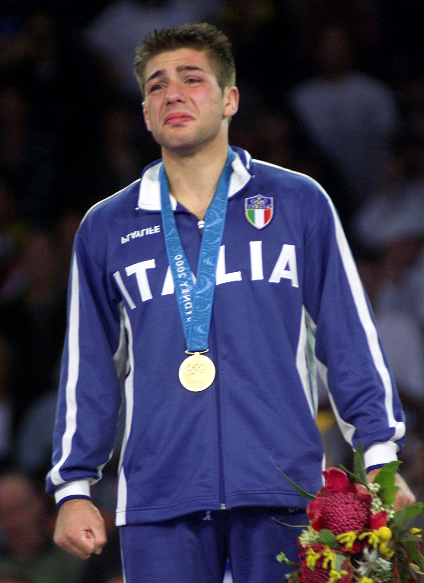 Italian Giuseppe Maddaloni cries as he stands on the with the gold medal after he won the men's judo 73kg final at the Sydney Summer Olympics, Monday, September 18, 2000. (AP Photo/Luca Bruno)
