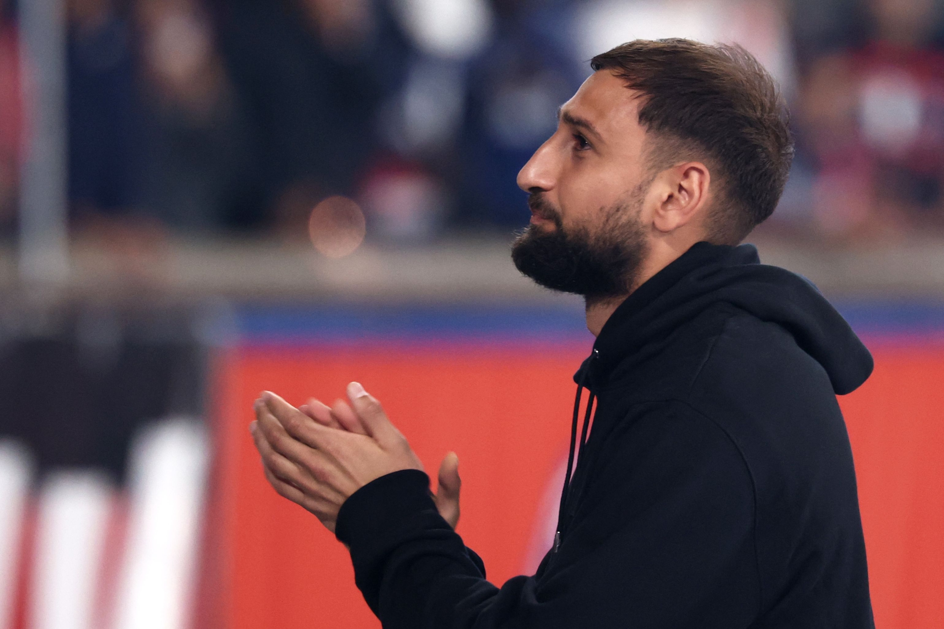 Paris Saint-Germain's Italian goalkeeper #01 Gianluigi Donnarumma cheers supporters as the club celebrates the 2024–2025 season's trophies (Ligue 1, Coupe de France, Trophée des Champions, the UEFA Champions League) and the UEFA Super Cup trophy, after the French L1 football match between Paris Saint-Germain (PSG) and Angers SCO at the Parc des Princes Stadium in Paris on August 22, 2025. (Photo by FRANCK FIFE / AFP)