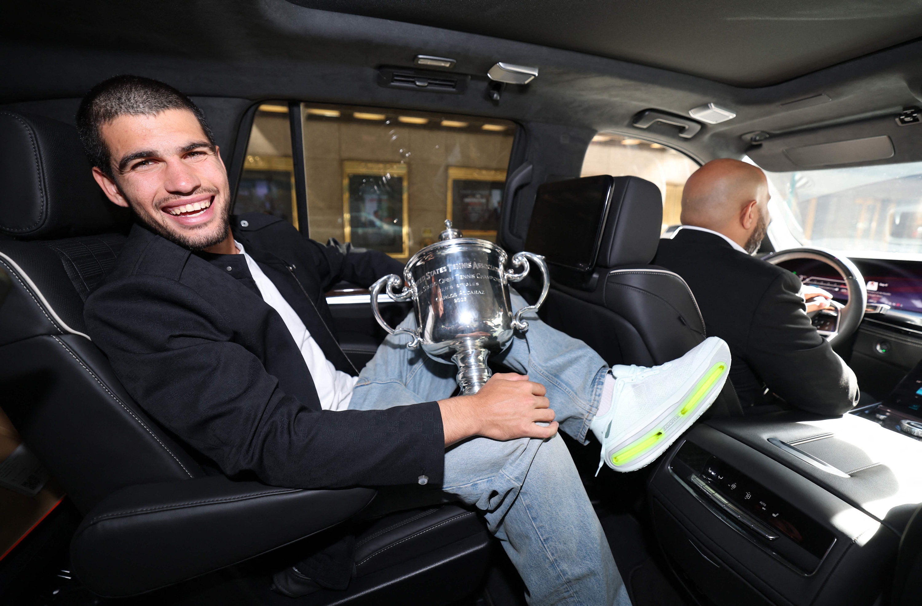Carlos Alcaraz with trophy in car