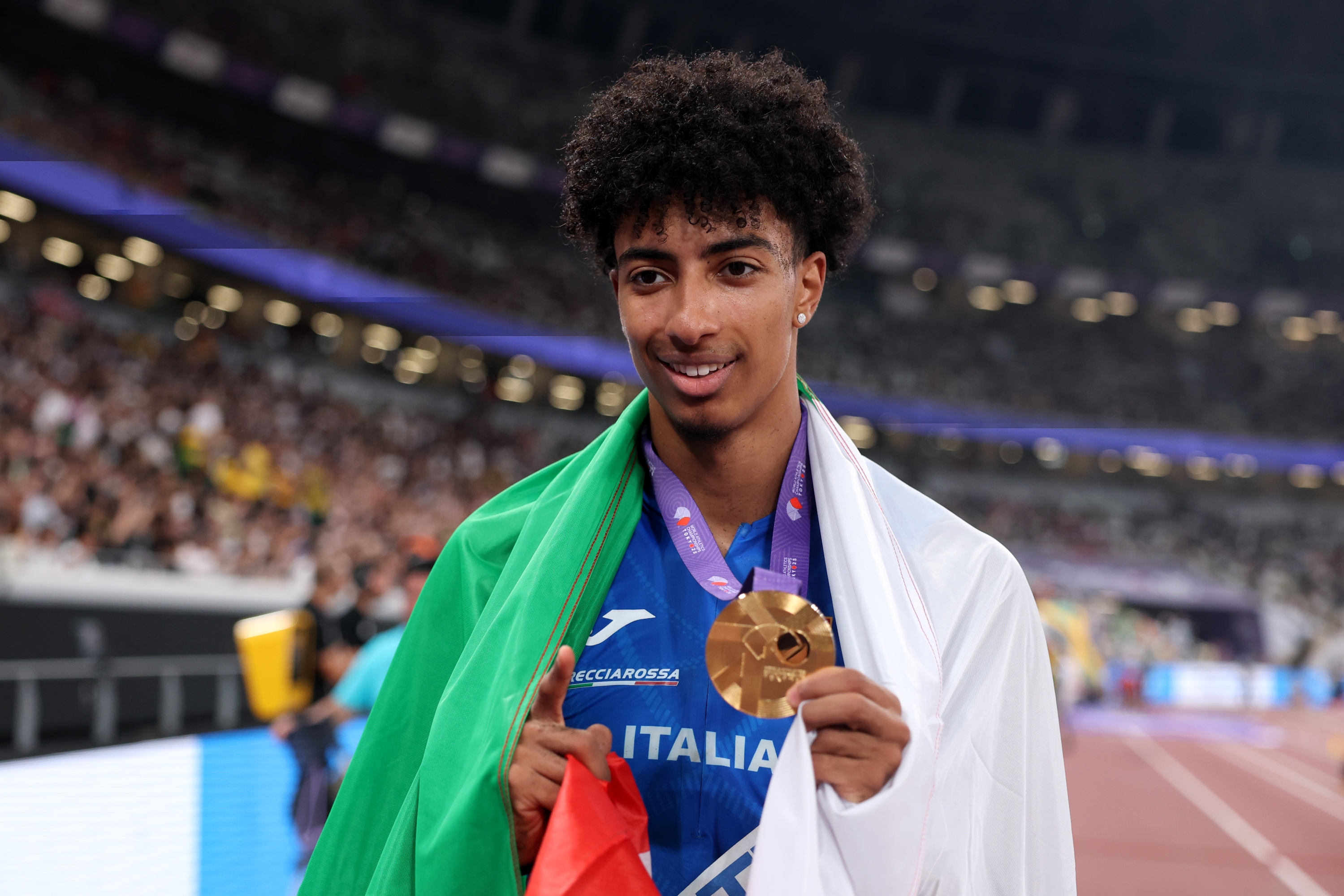Gold medalist Mattia Furlani of Team Italy poses for a photo with the national flag of Italy after winning the Men's Long Jump Final on day five of the World Athletics Championships Tokyo 2025 at National Stadium on September 17, 2025 in Tokyo, Japan. (Photo by Christian Petersen/Getty Images)
