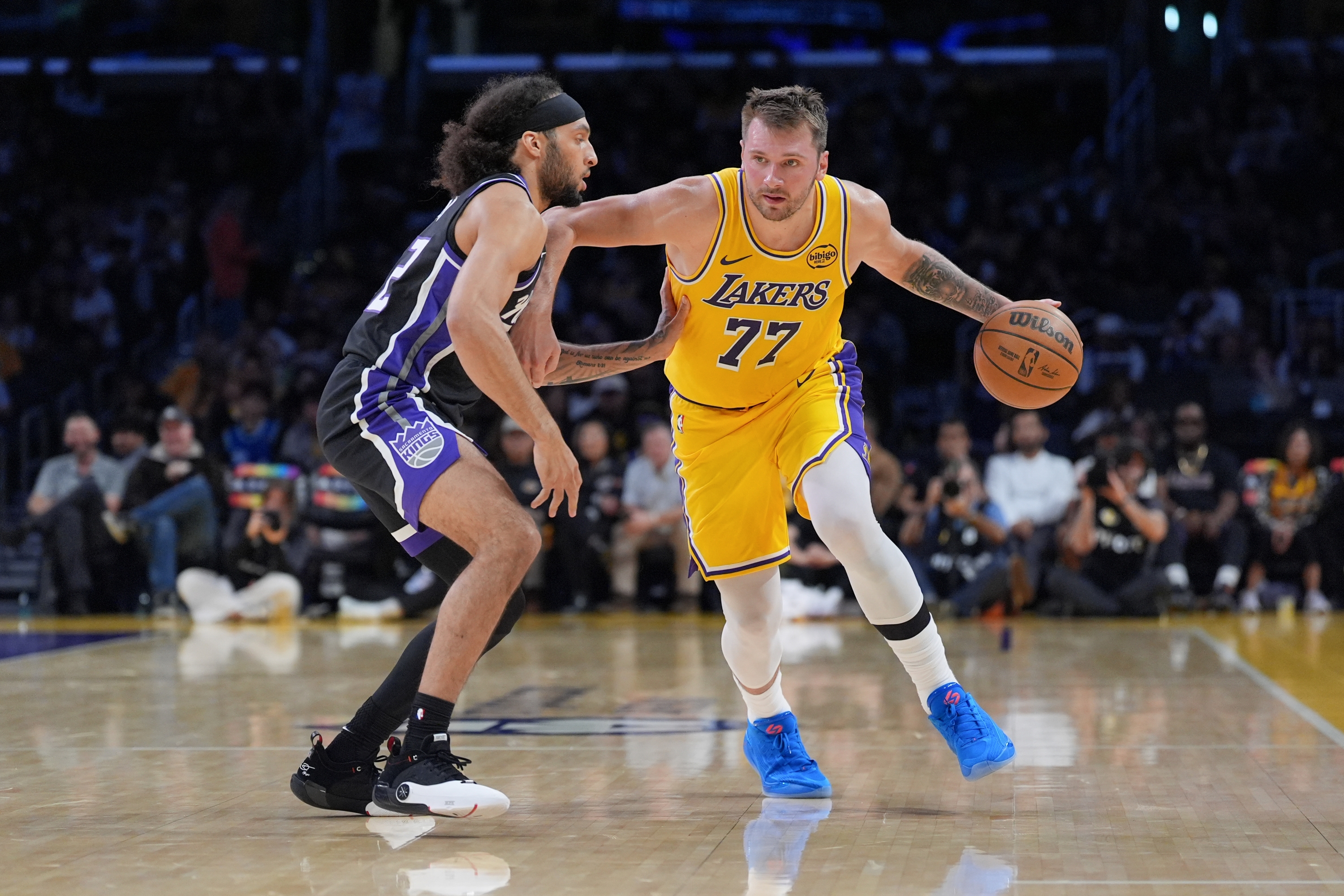 Los Angeles Lakers guard Luka Doncic (77) works around Sacramento Kings guard Devin Carter (22) during the first half of a preseason NBA basketball game Friday, Oct. 17, 2025, in Los Angeles. (AP Photo/Jae C. Hong)