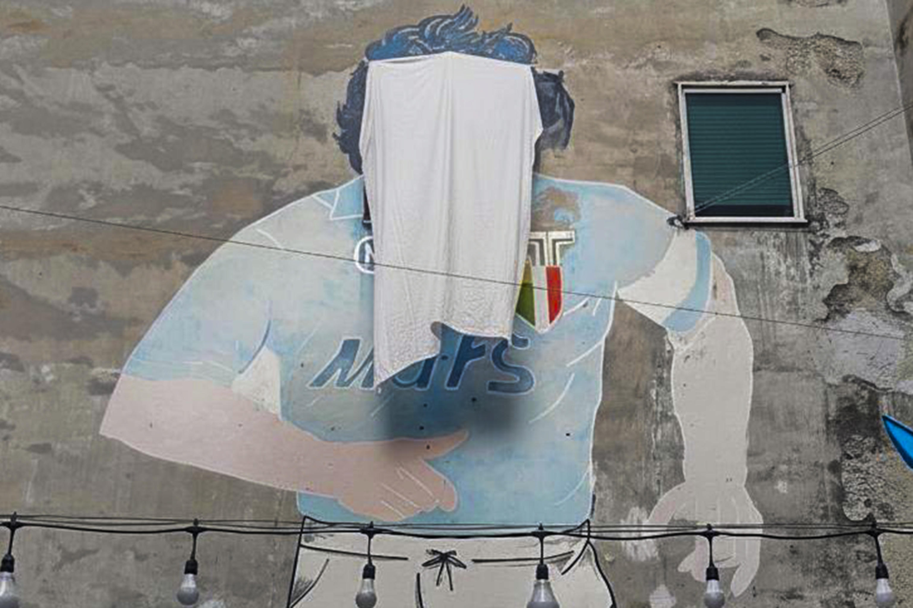 Il celebre murales dedicato a Maradona, nel 'santuario' per il Pibe de oro ai quartieri Spagnoli di Napoli, oggi coperto per qualche ora alla vista dei turisti per protesta dopo il blitz della Polizia Municipale che ha sequestrato magliette e gadgets,15 ottobre 2025. ANSA / CIRO FUSCO