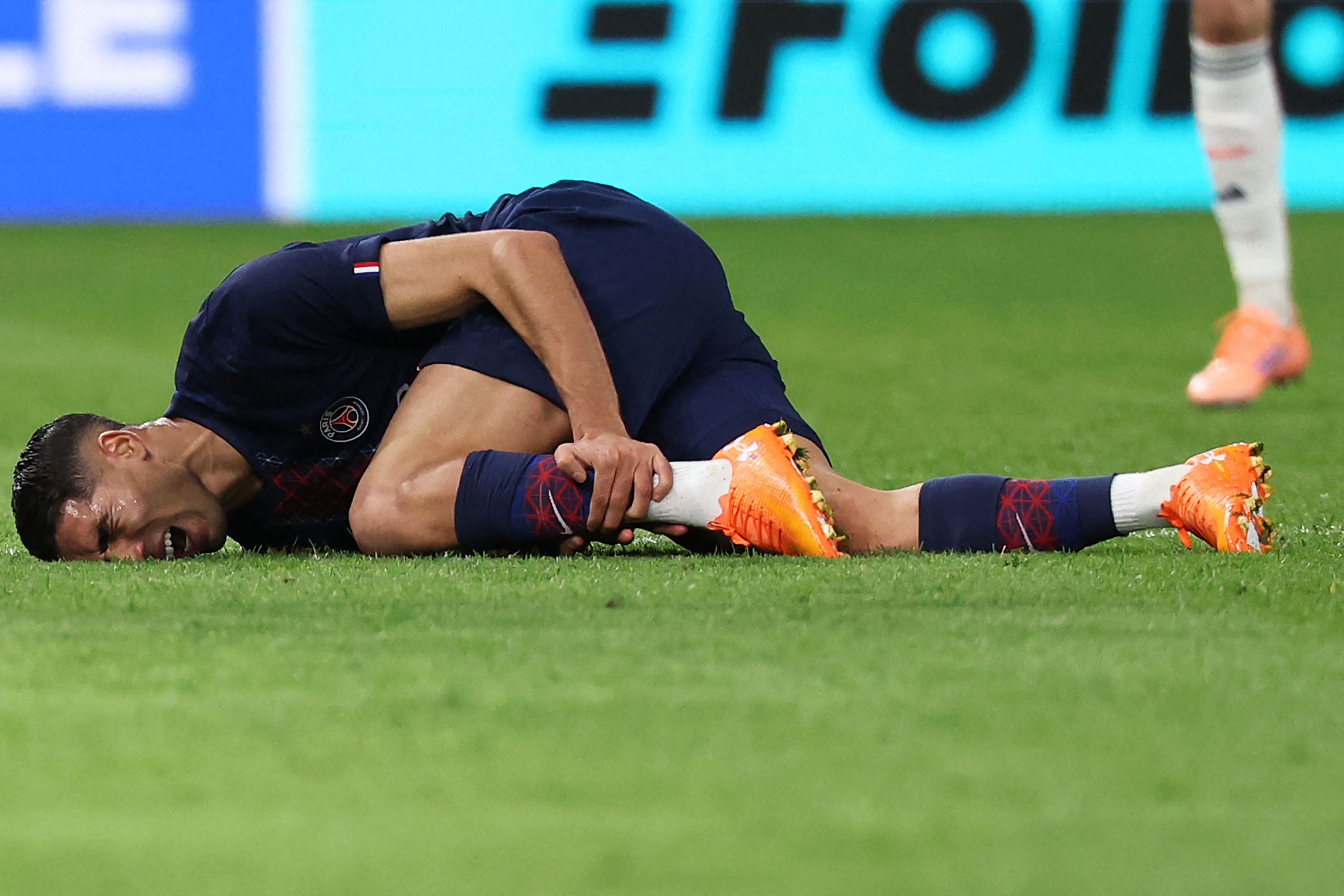 TOPSHOT - Paris Saint-Germain's Moroccan defender #02 Achraf Hakimi reacts after picking up an injury during the UEFA Champions League, league phase day 4, football match between Paris Saint-Germain (PSG) and FC Bayern Munich at the Parc des Princes in Paris, on November 4, 2025. (Photo by Anne-Christine POUJOULAT / AFP)