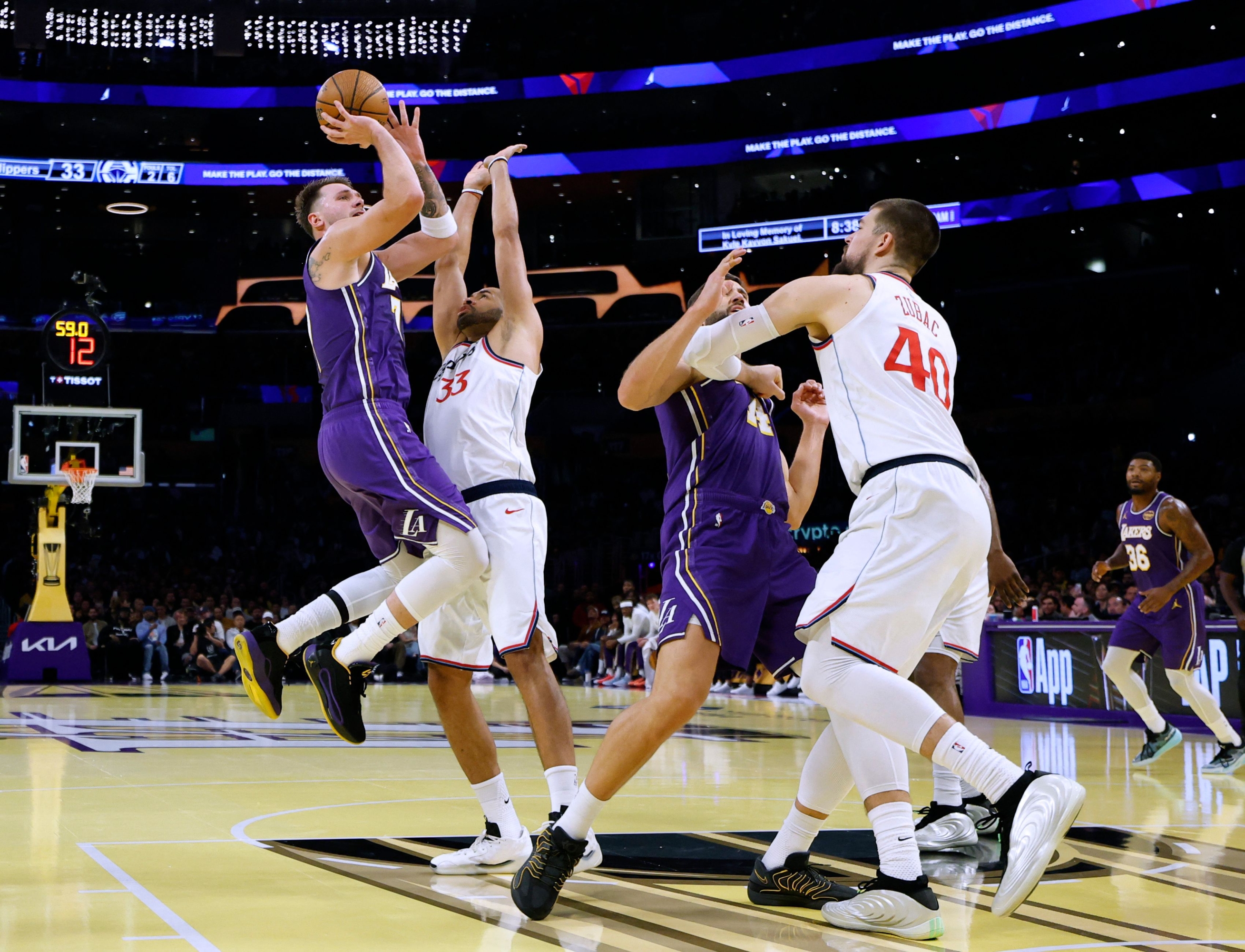  Luka Doncic #77 of the Los Angeles Lakers scores on a jumper in front of Nicolas Batum #33 and Ivica Zubac #40 of the LA Clippers with Maxi Kleber #14 during the first half at Crypto.com Arena on November 25, 2025 in Los Angeles, California.   Harry How/Getty Images/AFP NOTE TO USER: User expressly acknowledges and agrees that, by downloading and or using this photograph, User is consenting to the terms and conditions of the Getty Images License Agreement. (Photo by Harry How/Getty Images) (Photo by Harry How / GETTY IMAGES NORTH AMERICA / Getty Images via AFP)