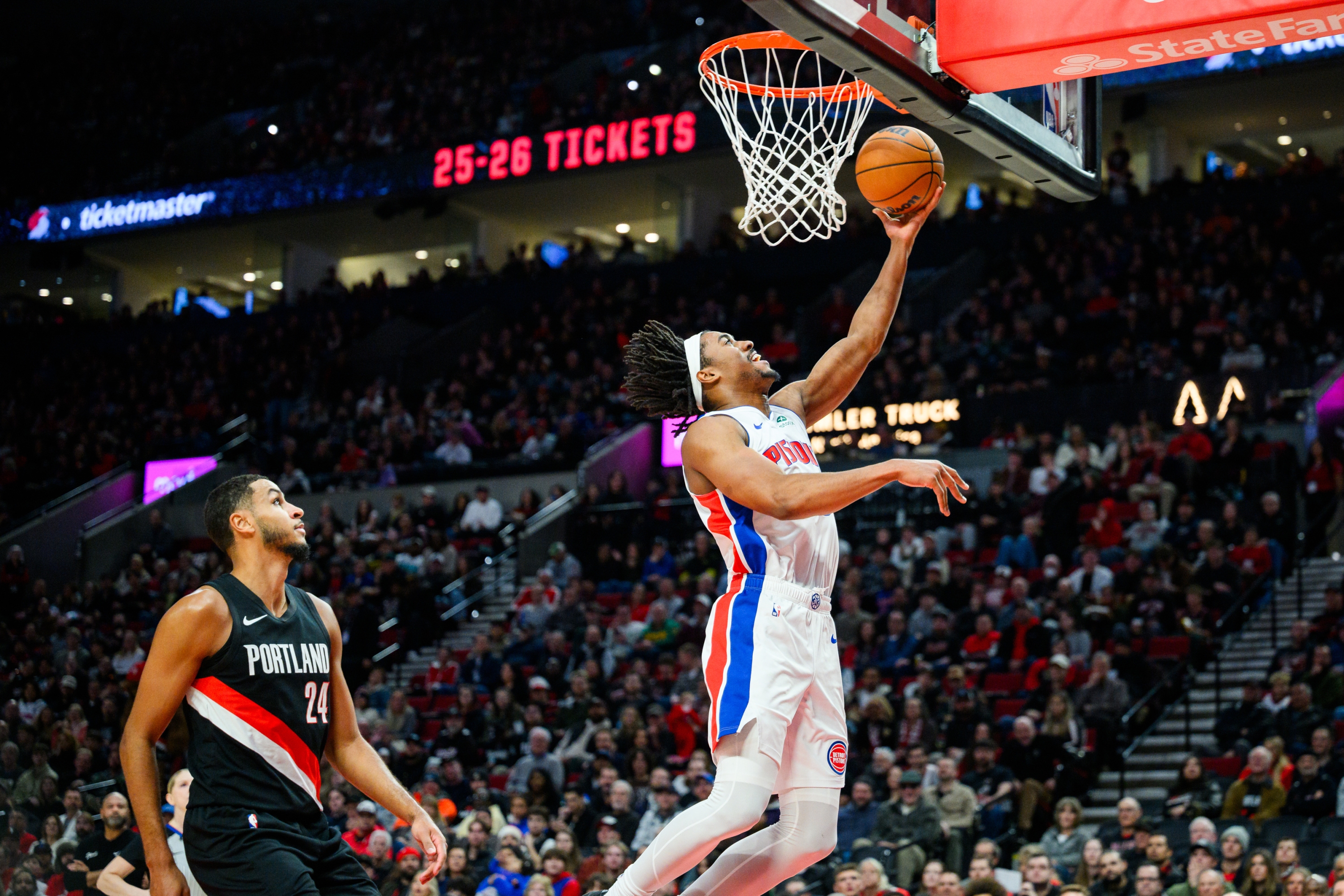 Detroit Pistons guard Jaden Ivey (23) goes up for a basket after winning a breakaway ball from Portland Trail Blazers forward Kris Murray (24) during the first half of an NBA basketball game, Monday, Dec. 22, 2025, in Portland, Ore. (AP Photo/Molly J. Smith)