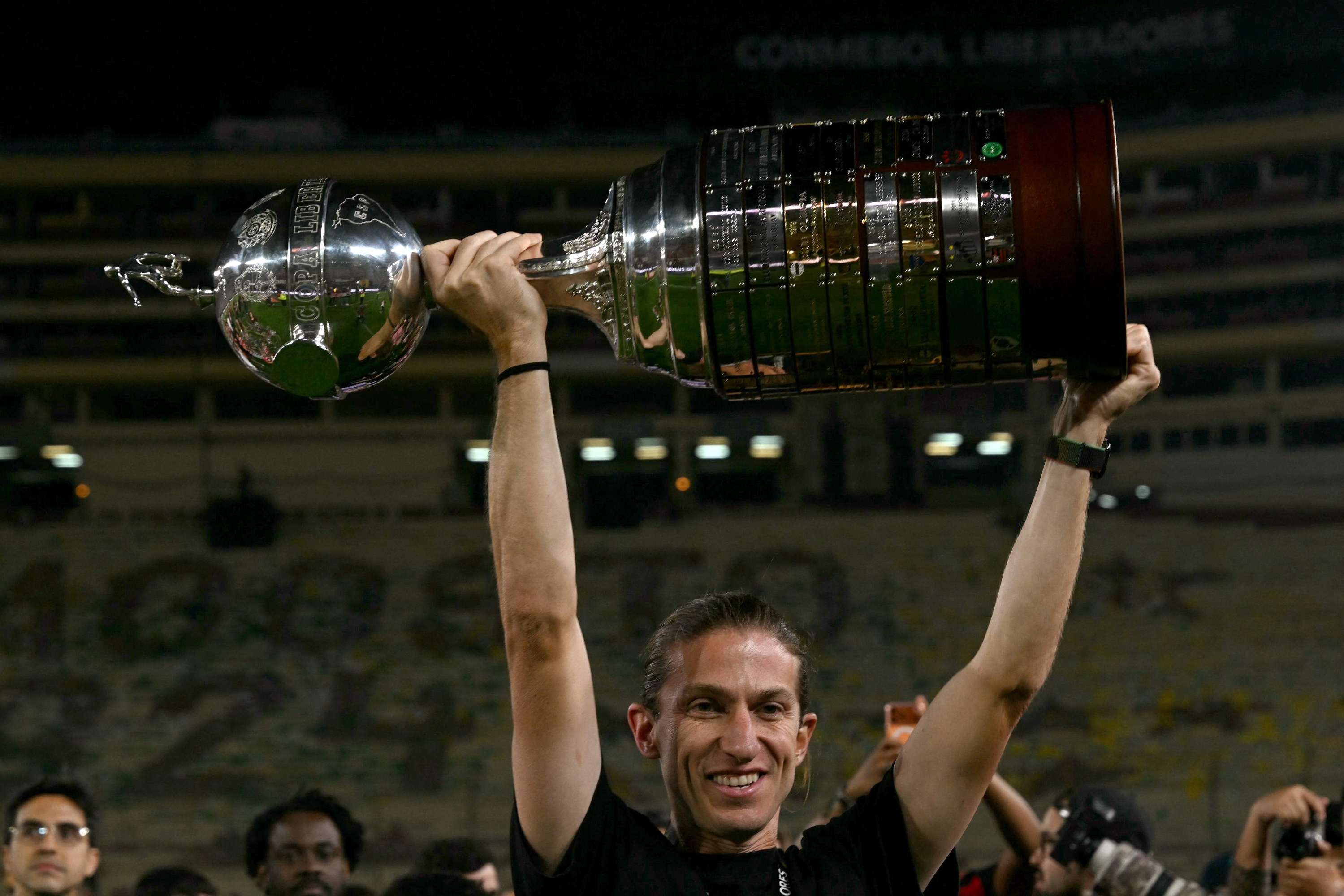 (FILES) Flamengo's head coach Filipe Luis lifts the trophy after winning the all Brazilian Copa Libertadores final football match between Palmeiras and Flamengo at Monumental 'U' Marathon stadium in Lima on November 29, 2025. Winner of the Brasileirão and Copa Libertadores in 2025, Filipe Luís was dismissed on March 3, 2026 as Flamengo's coach after a poor start to the season in which he lost the Recopa Sudamericana and the Brazilian Super Cup. (Photo by Luis ACOSTA / AFP)