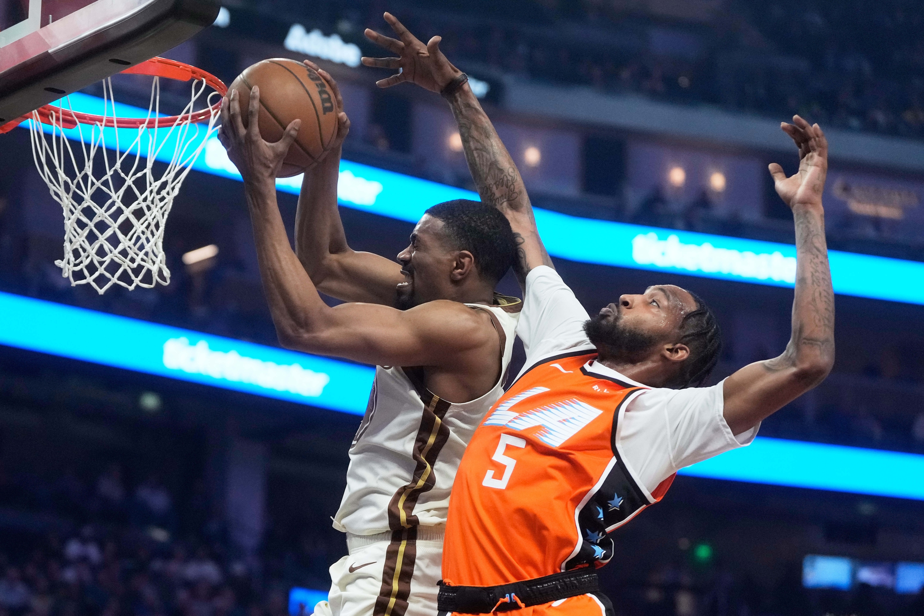 Golden State Warriors guard De'Anthony Melton, left, grabs a rebound against Los Angeles Clippers forward Derrick Jones Jr. (5) during the first half of an NBA basketball game in San Francisco, Monday, March 2, 2026. (AP Photo/Jeff Chiu)